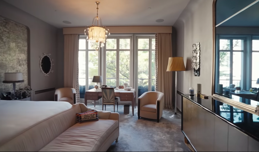 The primary bedroom softens the home's mood after the darker, more theatrical spaces. Its silvery palette feels serene and quietly expensive. | Source: YouTube/Architectural Digest