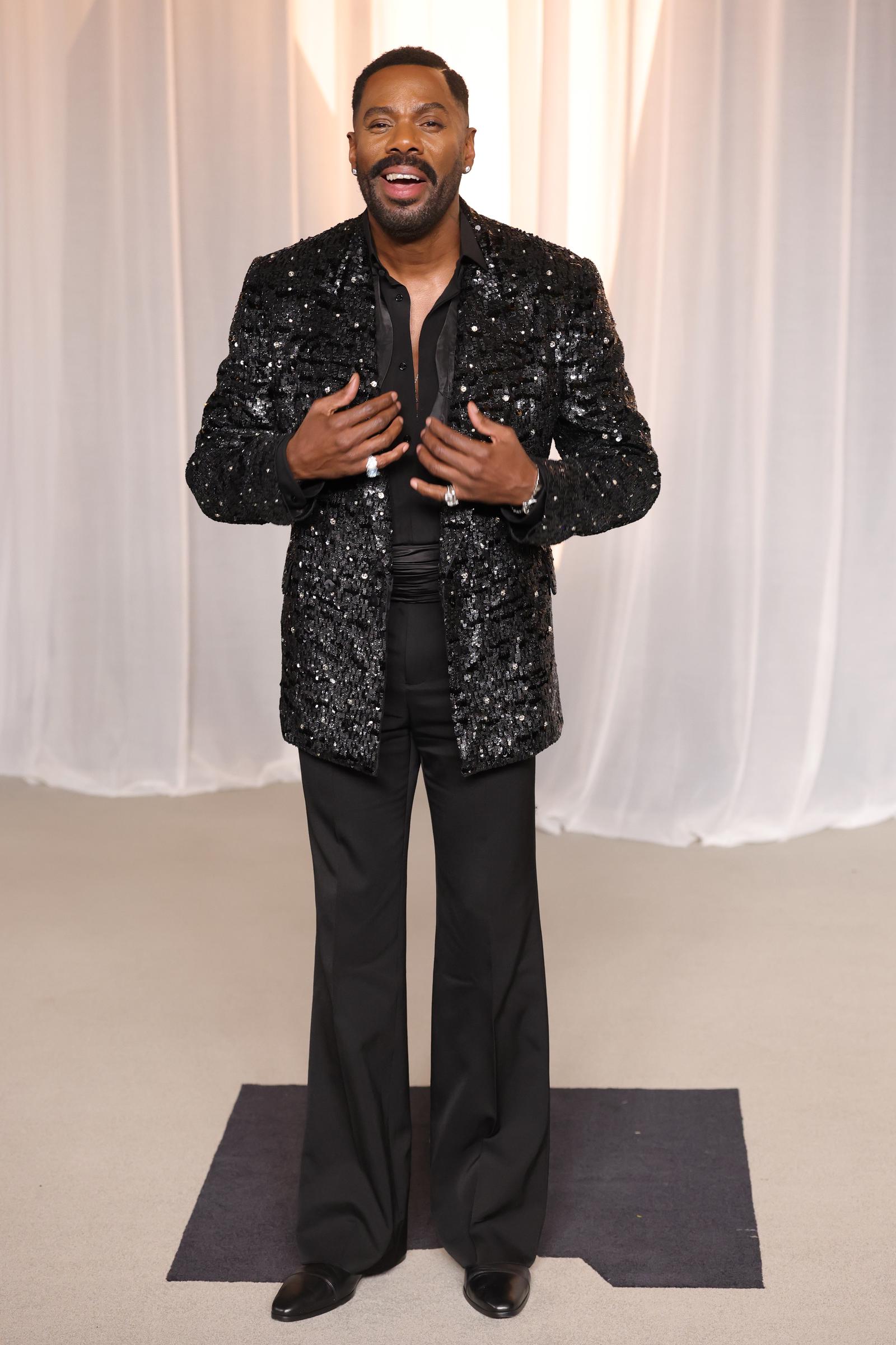 Colman Domingo turns heads in an impeccably tailored black ensemble anchored by a glittering sequined jacket, relaxed wide-leg trousers, and sparkling statement rings. Wearing a deep open collar and flashing a broad smile, the actor pairs polished sophistication with his signature daring flair as he celebrates receiving the Vantage Award.