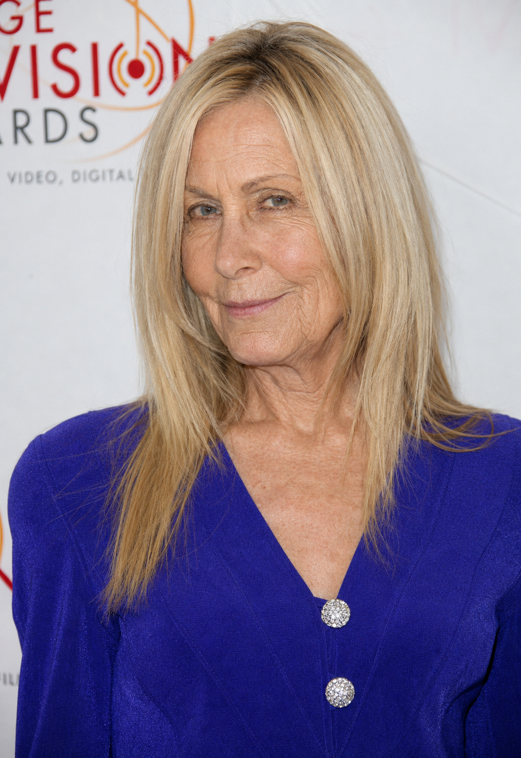 With a knowing smile and vibrant styling, this interpretation presents a more playful side of Joan Van Ark. Instead of focusing on dramatic transformation, the AI imagines how her familiar features might have matured while allowing her confidence and charisma to remain unmistakably intact. | Source: ChatGPT