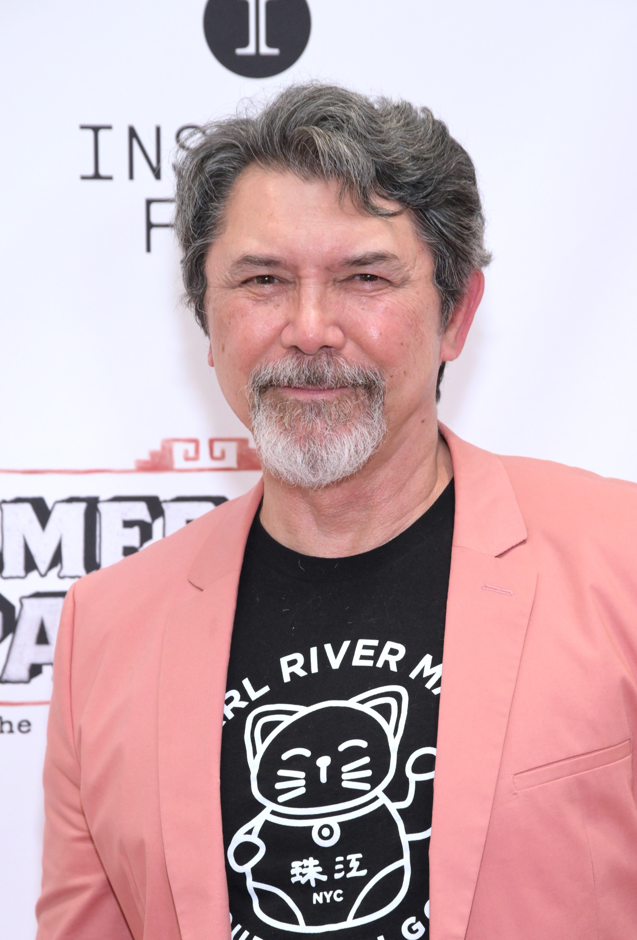 Lou Diamond Phillips attends an event in a pink blazer and graphic T-shirt. | Source: Getty Images