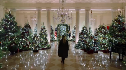 Melania Trump standing before rows of beautifully-decorated Christmas trees. | Source: Facebook/First Lady Melania Trump