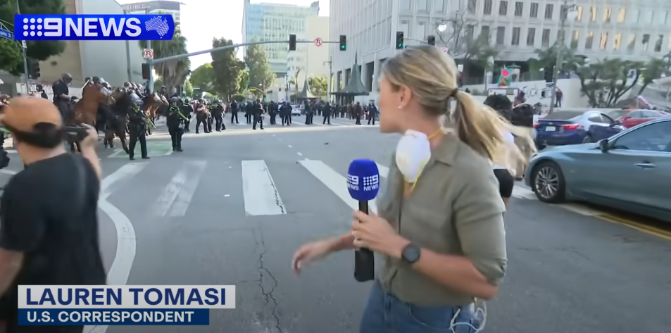 Lauren Tomasi reporting from Downtown Los Angeles during confrontations between the U.S. National Guard and protestors on June 8, 2025 | Source: Youtube/9 News Australia