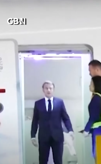Emmanuel Macron with two crew members standing to the side after Brigitte pushed his face. | Source: YouTube/GBNews