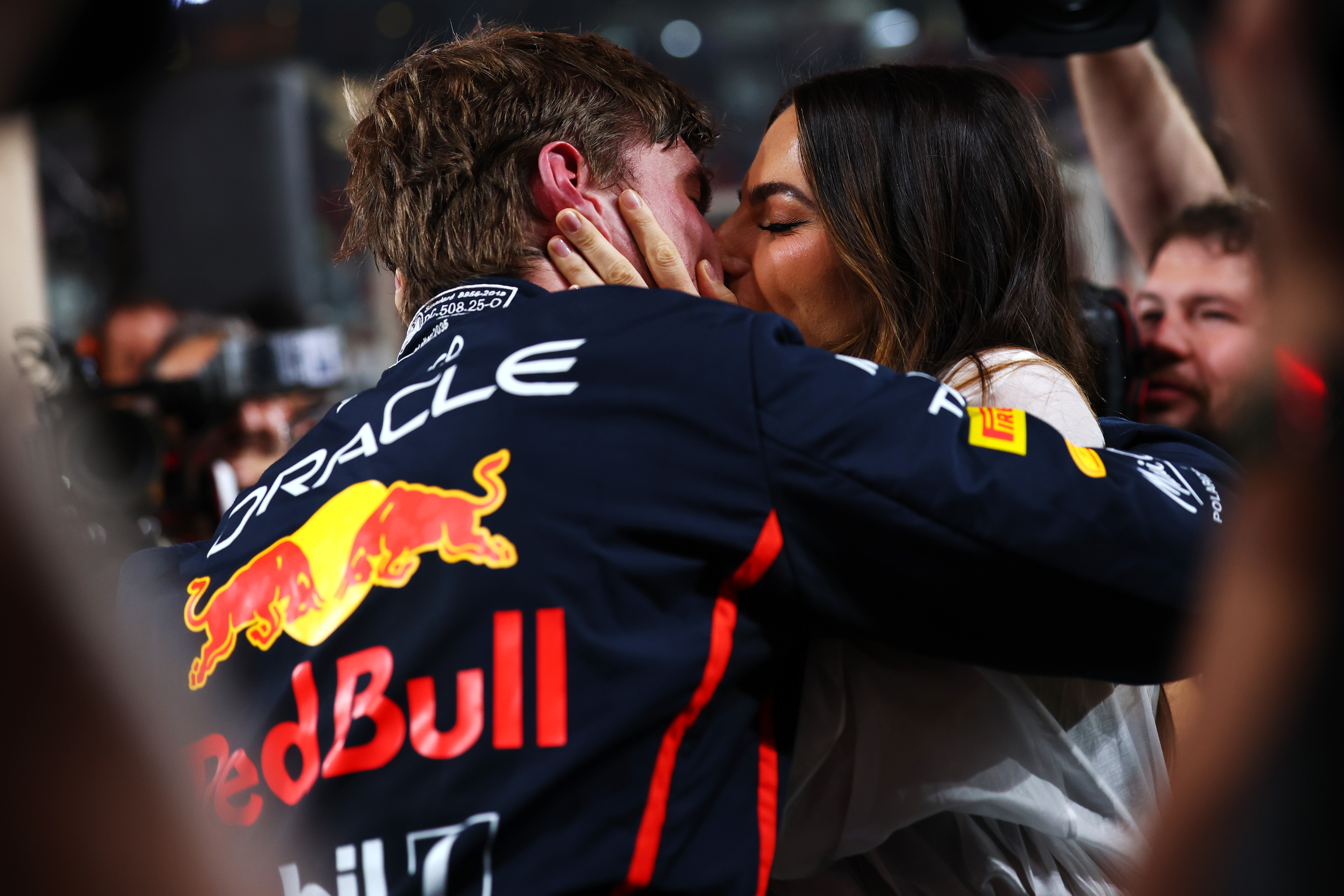 Kelly Piquet kisses Max Verstappen in the parc fermé during qualifying ahead of the Formula One Grand Prix of Abu Dhabi at Yas Marina Circuit in Abu Dhabi, United Arab Emirates, on December 6, 2025, celebrating his strong performance that secured the top starting spot.