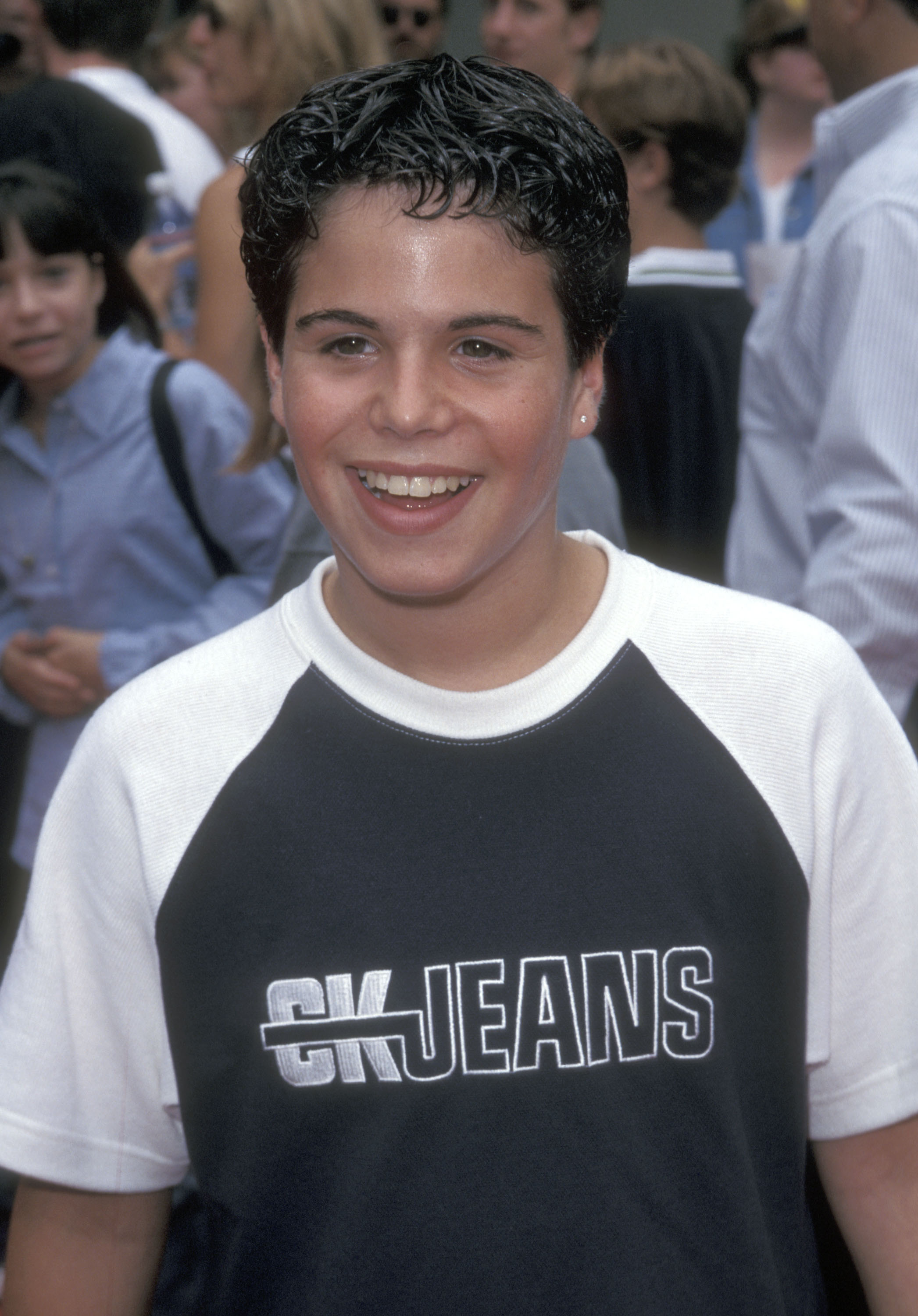 The young actor smiles at the premiere of Kull the Conqueror, sporting short, styled hair and a casual CK Jeans shirt — a noticeably more grown-up look than in his early Hollywood years. | Source: Getty Images.