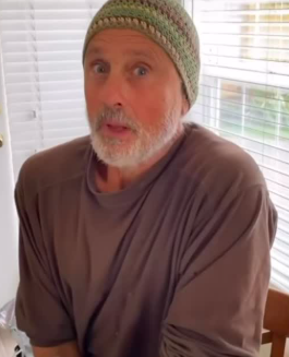 In one clip, Matt appears indoors with a gray beard, wearing a knitted cap and an oversized brown shirt. There is little Hollywood gloss to the moment. Instead, fans see an older Matt in a candid family setting — expressive, relaxed, and almost unrecognizable from the young dancer associated with Olivia's 1980s life. | Source: Instagram/chloelattanziofficial