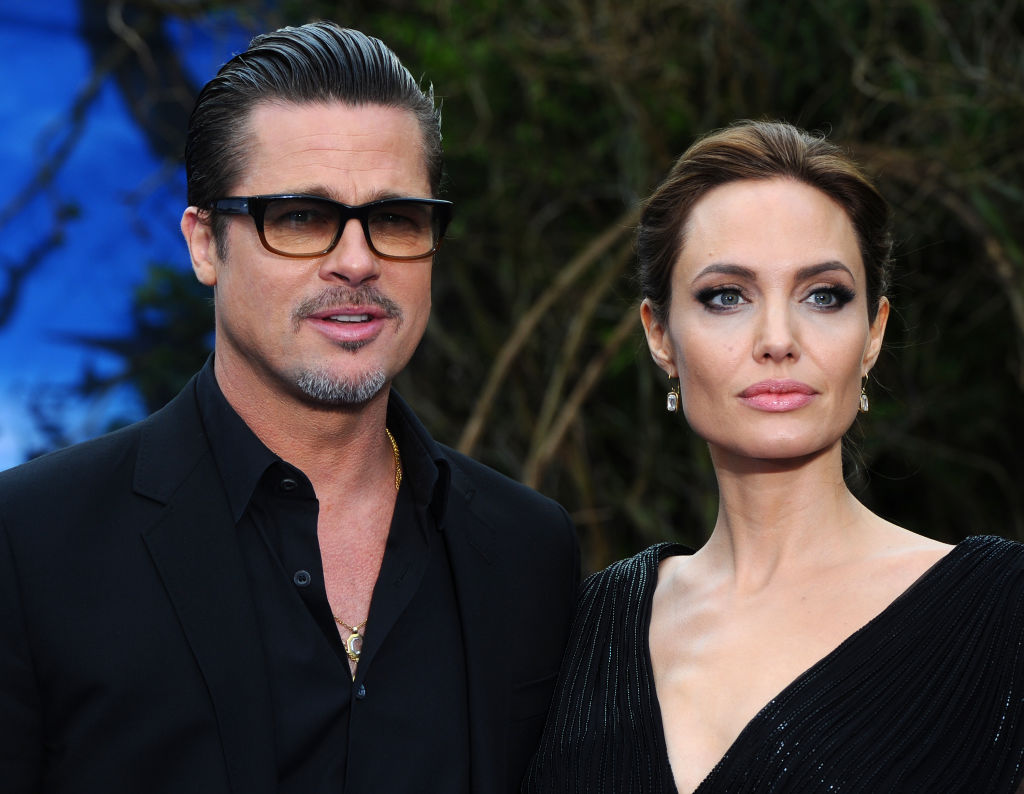 Angelina Jolie and Brad Pitt attend the AFI Awards luncheon in Beverly Hills, posing indoors in coordinated black-and-white looks during the industry event.