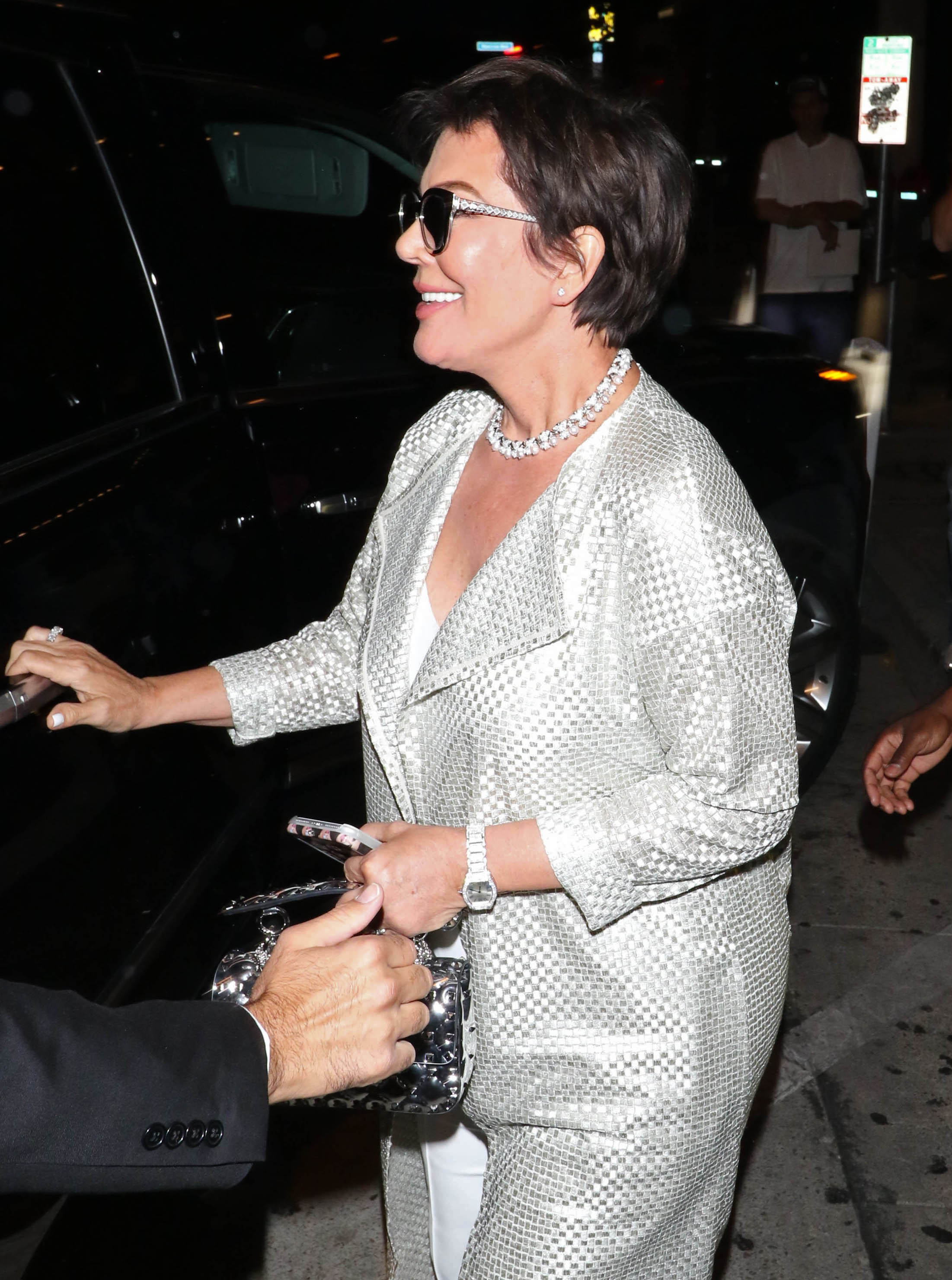 Kris Jenner is seen arriving in Los Angeles, wearing a shimmering silver jacket and sunglasses. | Source: Getty Images