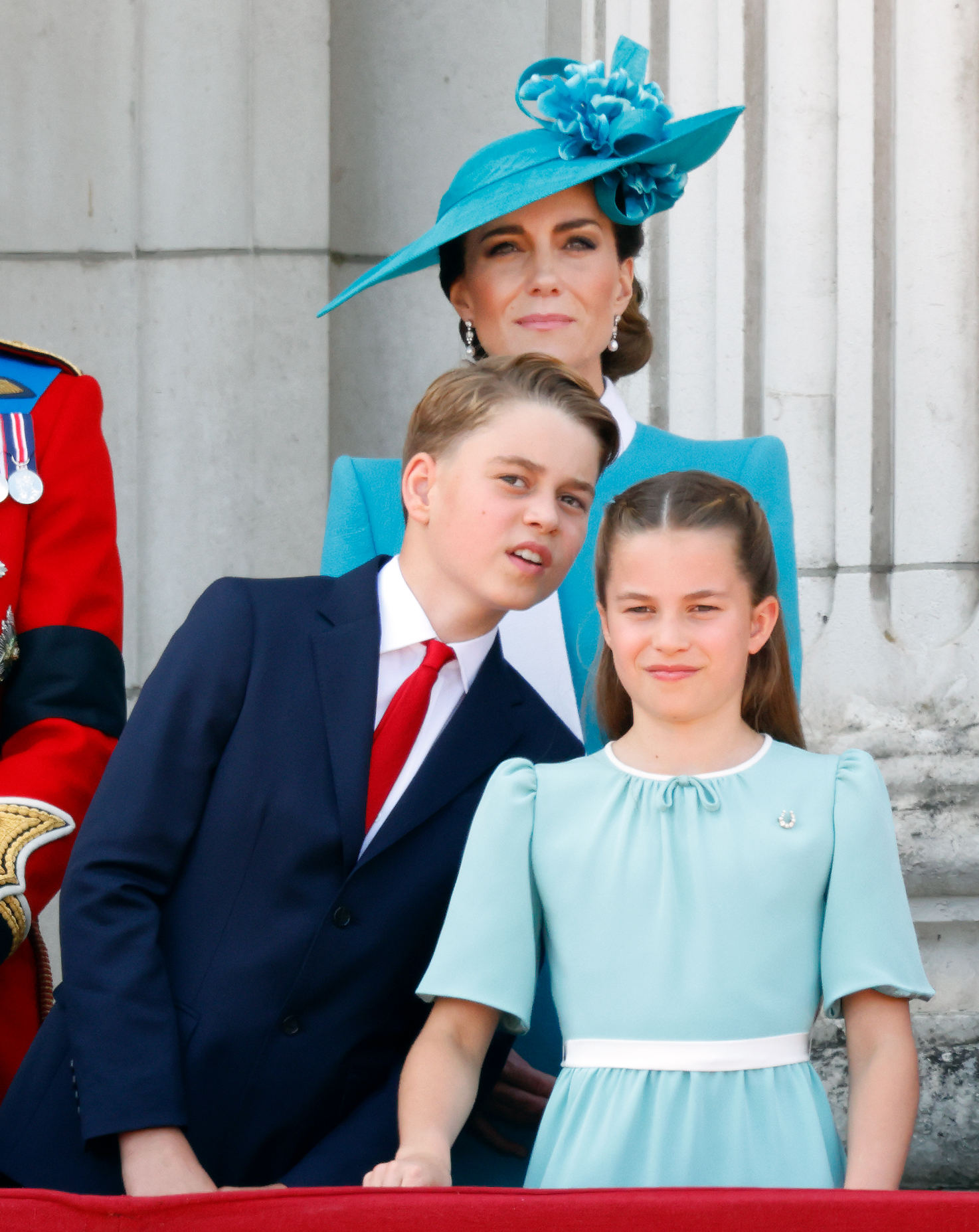 Prince George lookes over Princess Charlotte's shoulder while watching the RAF flypast from the balcony of Buckingham Palace during the 2025 Trooping the Colour festivities.