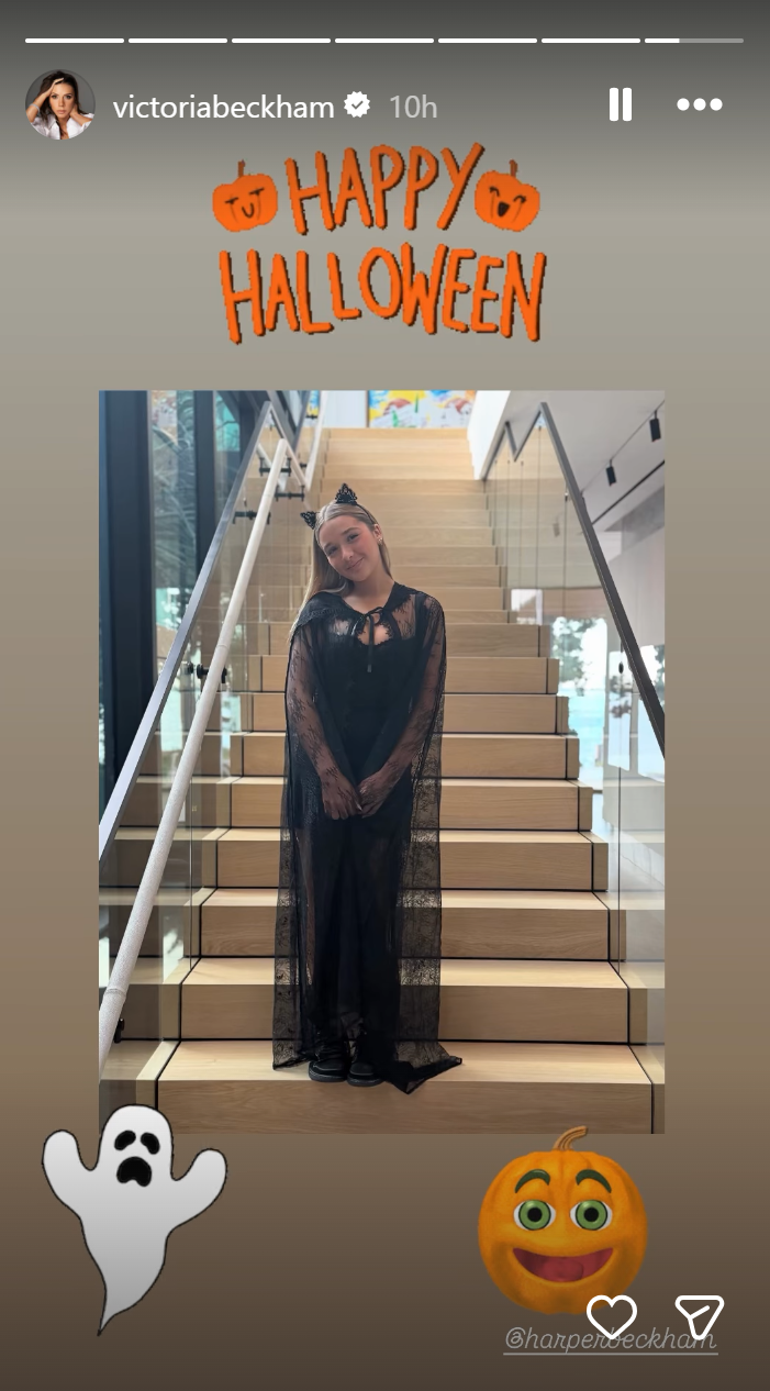 In a post dated November 1, 2025, Victoria and David Beckham's daughter, Harper Beckham, embraced a spooky-chic aesthetic in a flowing black lace cape worn over a fitted black outfit. Her look was finished with black platform shoes and a delicate cat ear headband adorned with subtle embellishments. With her hair down and a soft smile, she struck a playful pose on a staircase, delivering a modern, elegant take on the classic black cat costume. | Source: Instagram/victoriabeckham