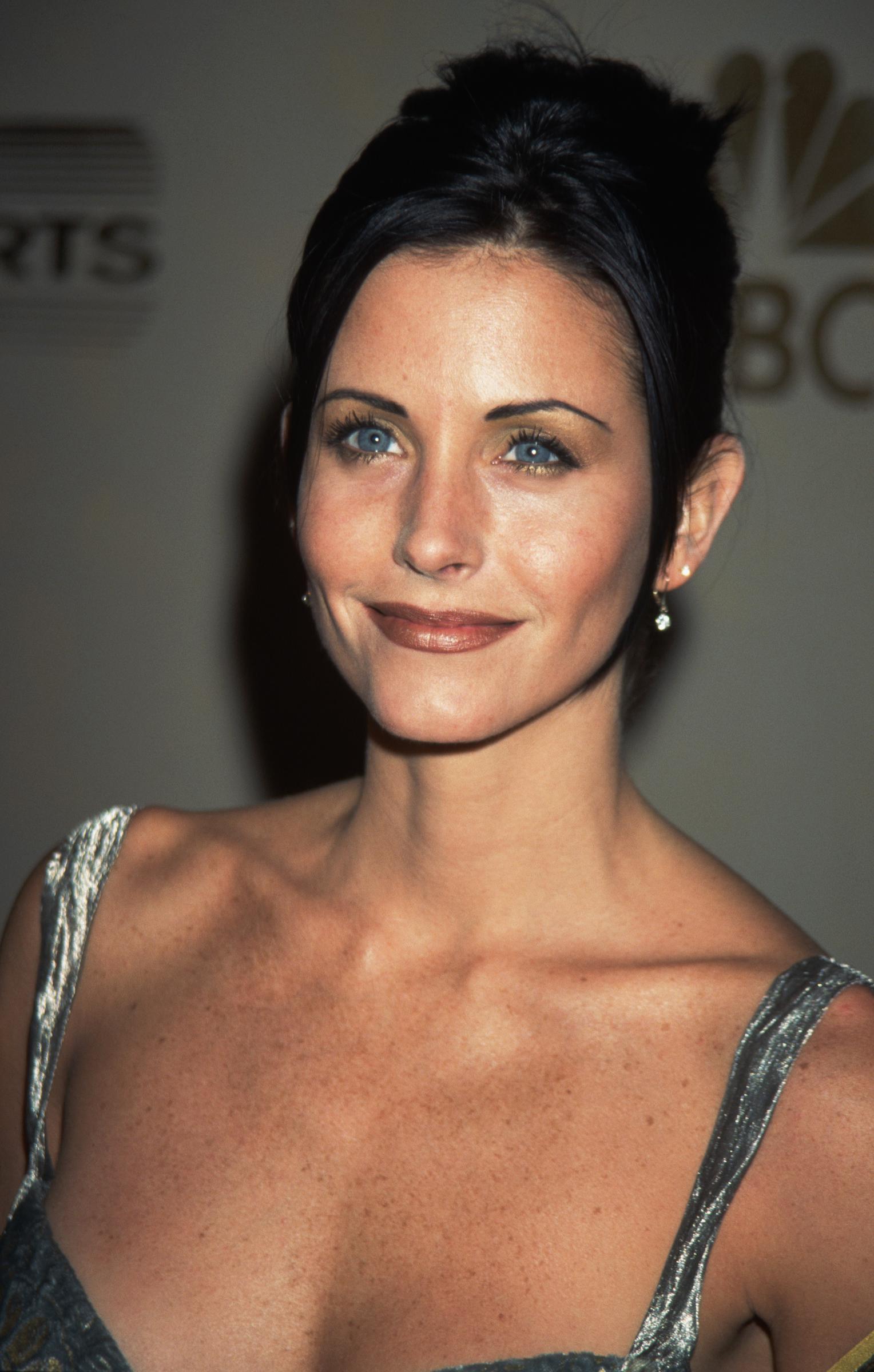 In 1997, at the height of "Friends" fame, Courteney Cox dazzles in a stunning silver dress, embodying the elegance of her Monica Geller era.