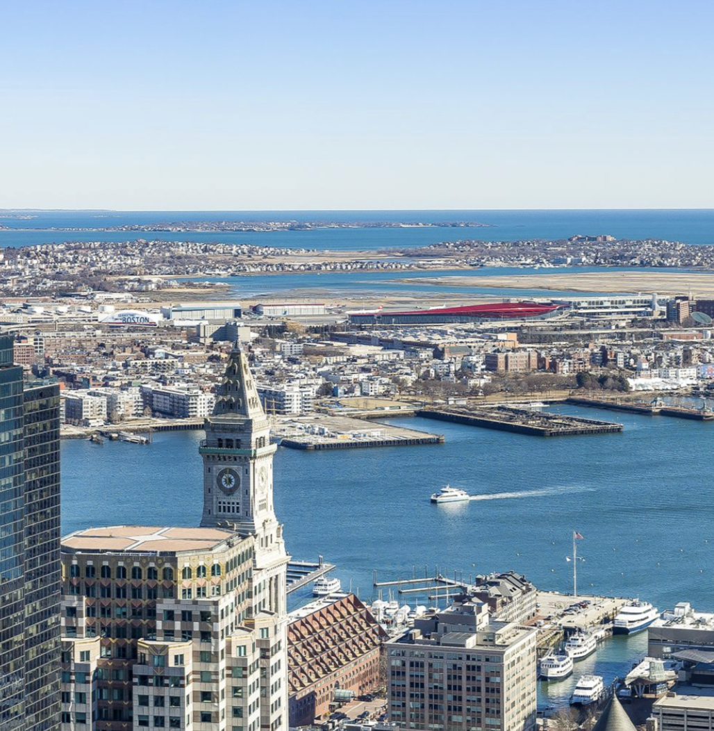 The Boston penthouse overlooks the harbor, with the historic Custom House Tower and Logan Airport visible in the distance. | Source: Instagram/ @robbreport