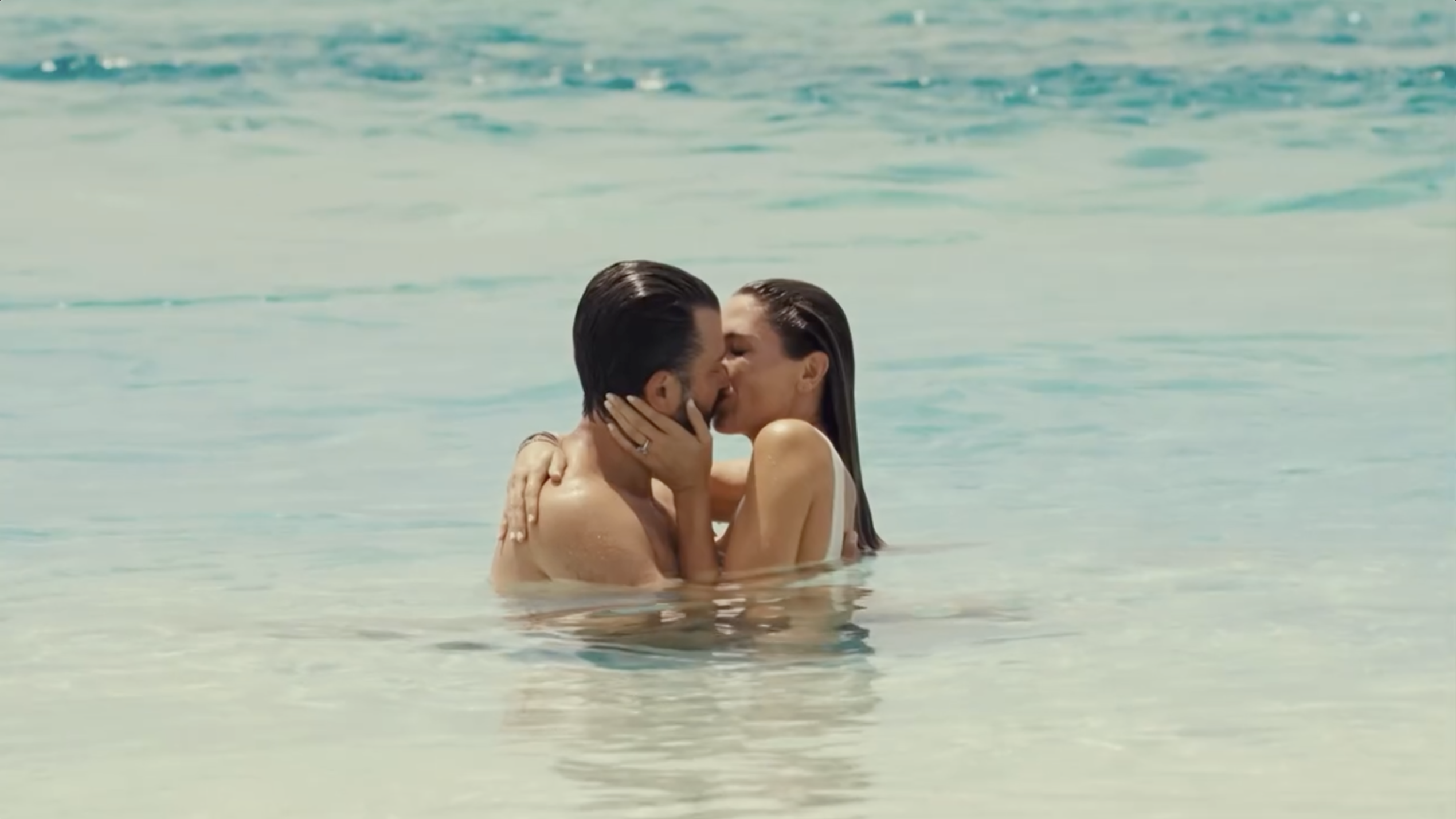 Donald Trump Jr. and Bettina Anderson embrace in the shallow sea as the couple shares a kiss surrounded by calm Caribbean waters. | Source: Instagram/donaldjtrumpjr