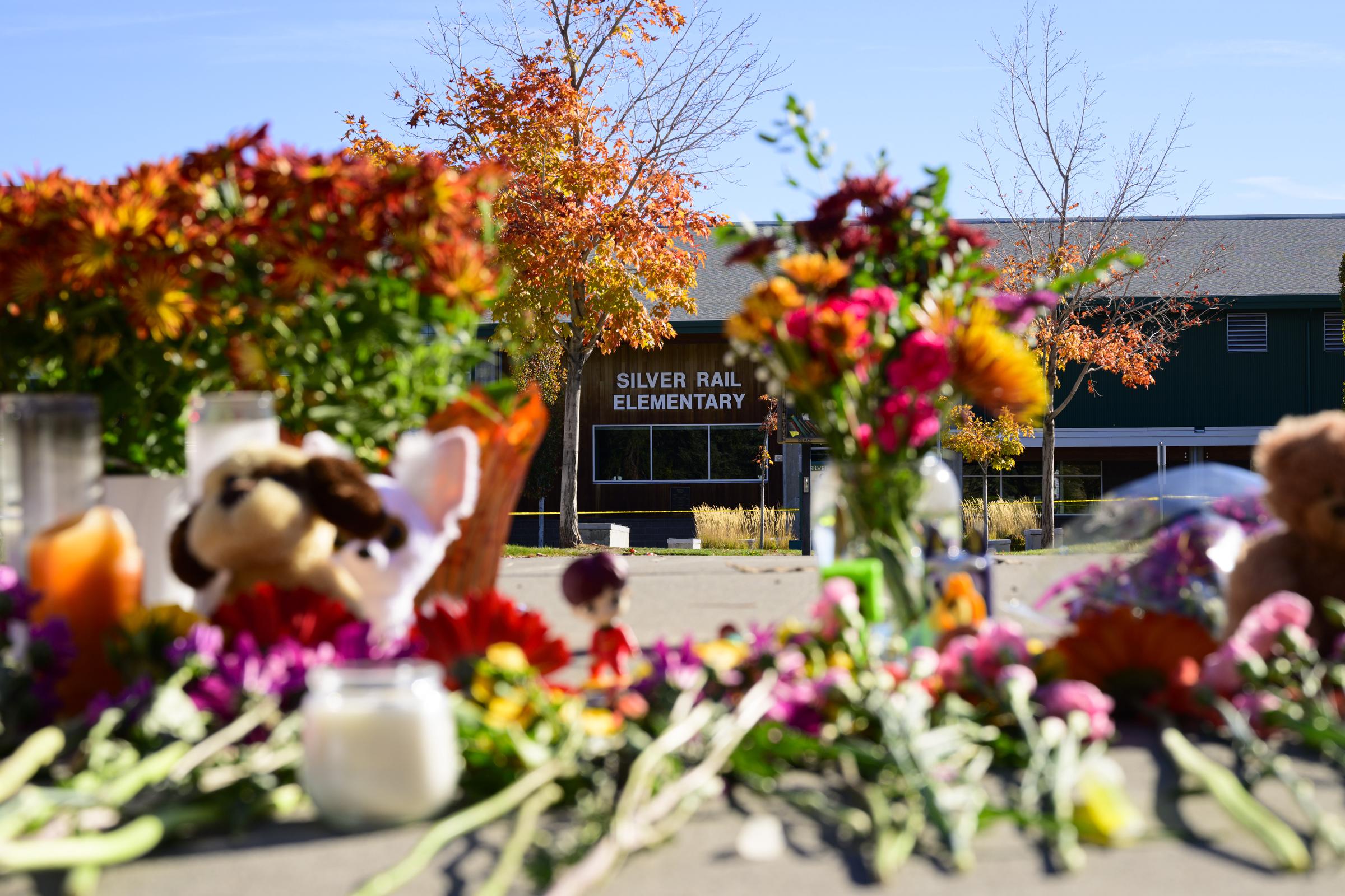 Flowers, stuffed animals, and candles fill a memorial outside Silver Rail Elementary, where the community gathered to honor the three children and teacher killed in the shooting. | Source: Getty Images.