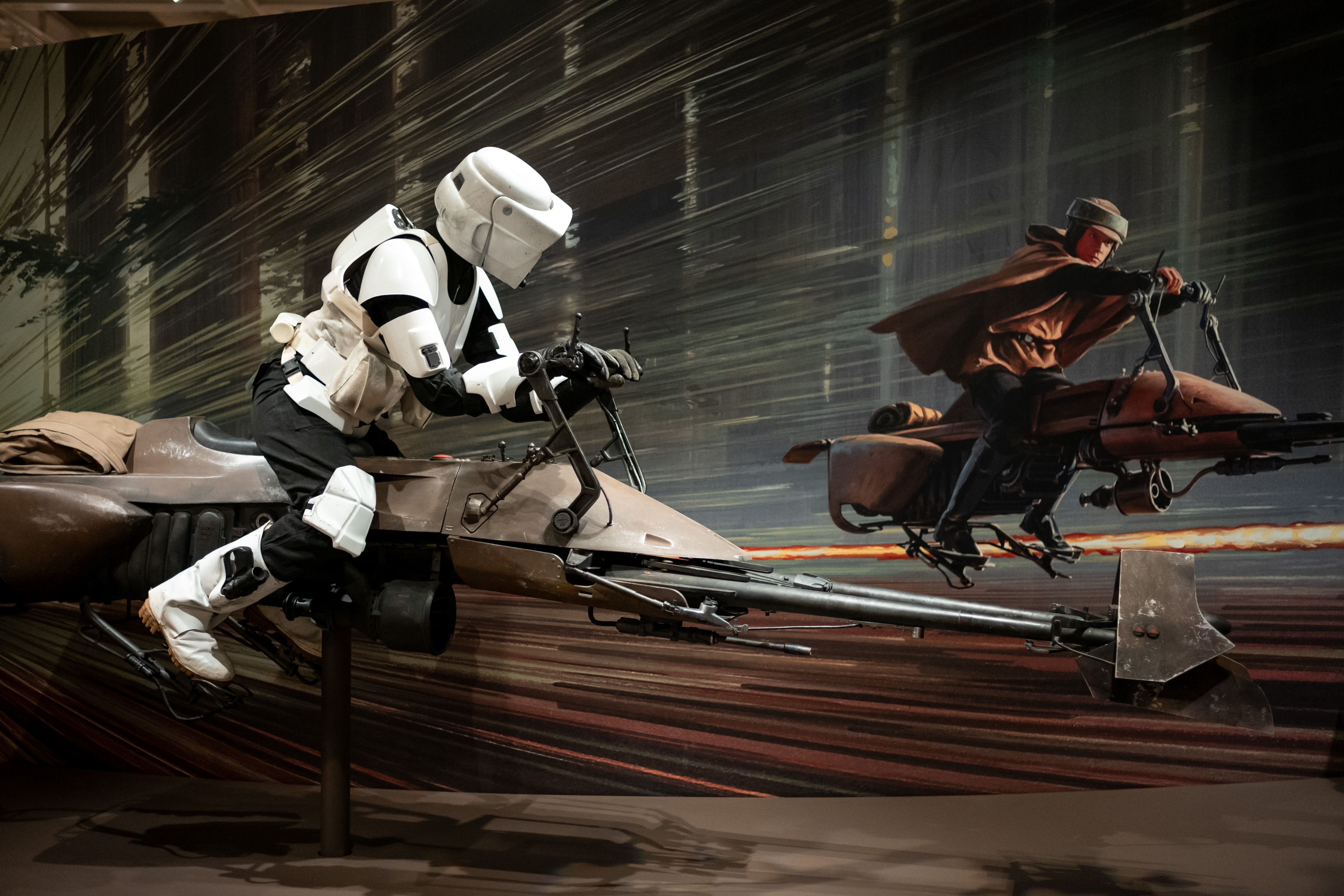 Another display recreates the speed and action associated with the "Star Wars" films, placing a scout trooper on a speeder bike against a motion-filled backdrop. The installation shows how the museum presents cinematic objects within a larger visual scene. | Source: Getty Images