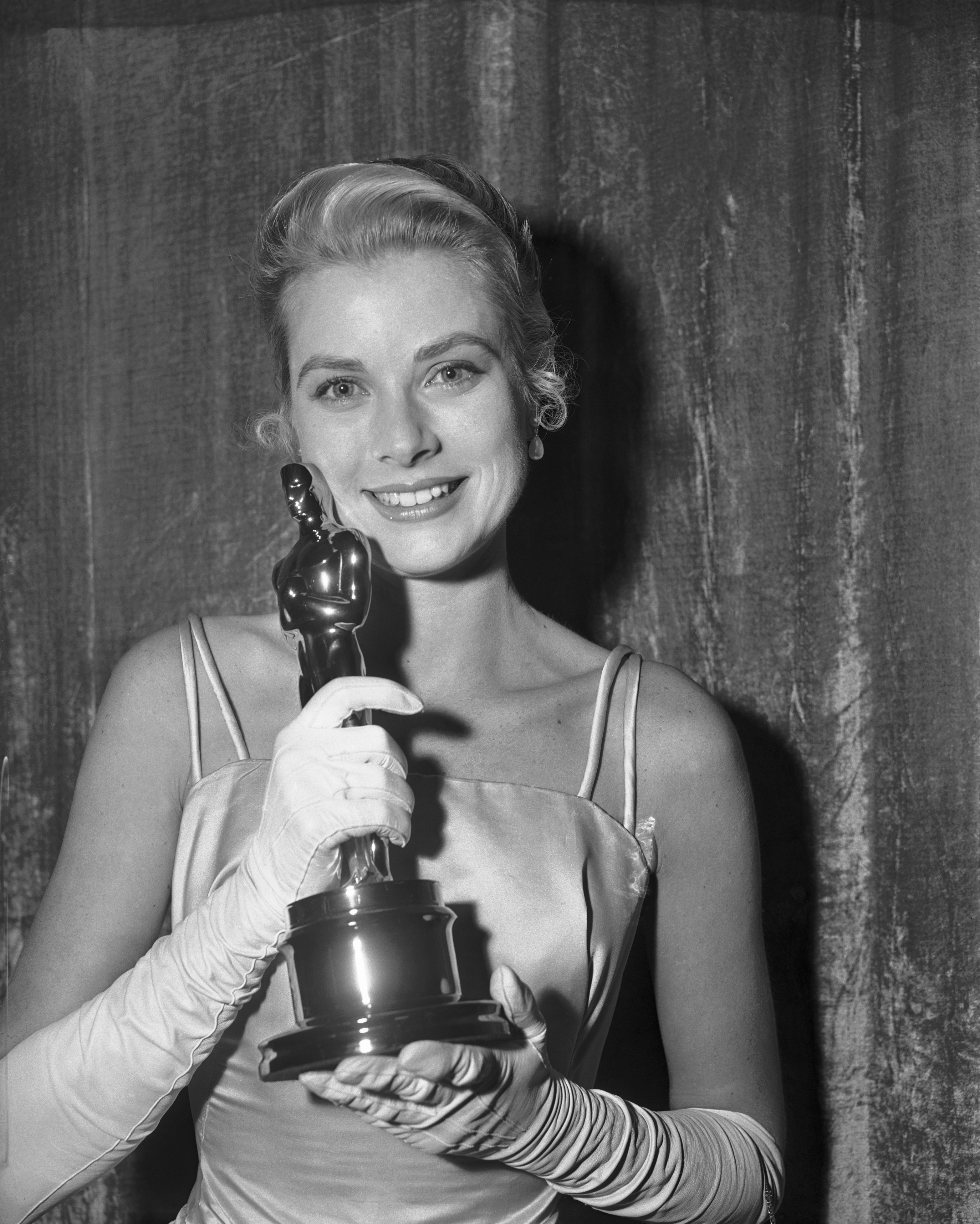 Grace Kelly hugs her Oscar after she was honored as the best actress at the 27th Academy Awards, dated April 1, 1955 | Source: Getty Images