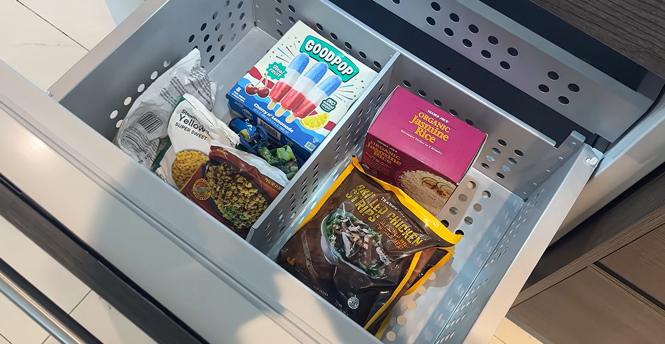 A freezer contains frozen meals and other groceries featured in Kai Trump's August 2026, vlog. Her friend Emma brought food after Trump said she had barely eaten for three days while feeling ill. | Source: Youtube/kaitrump