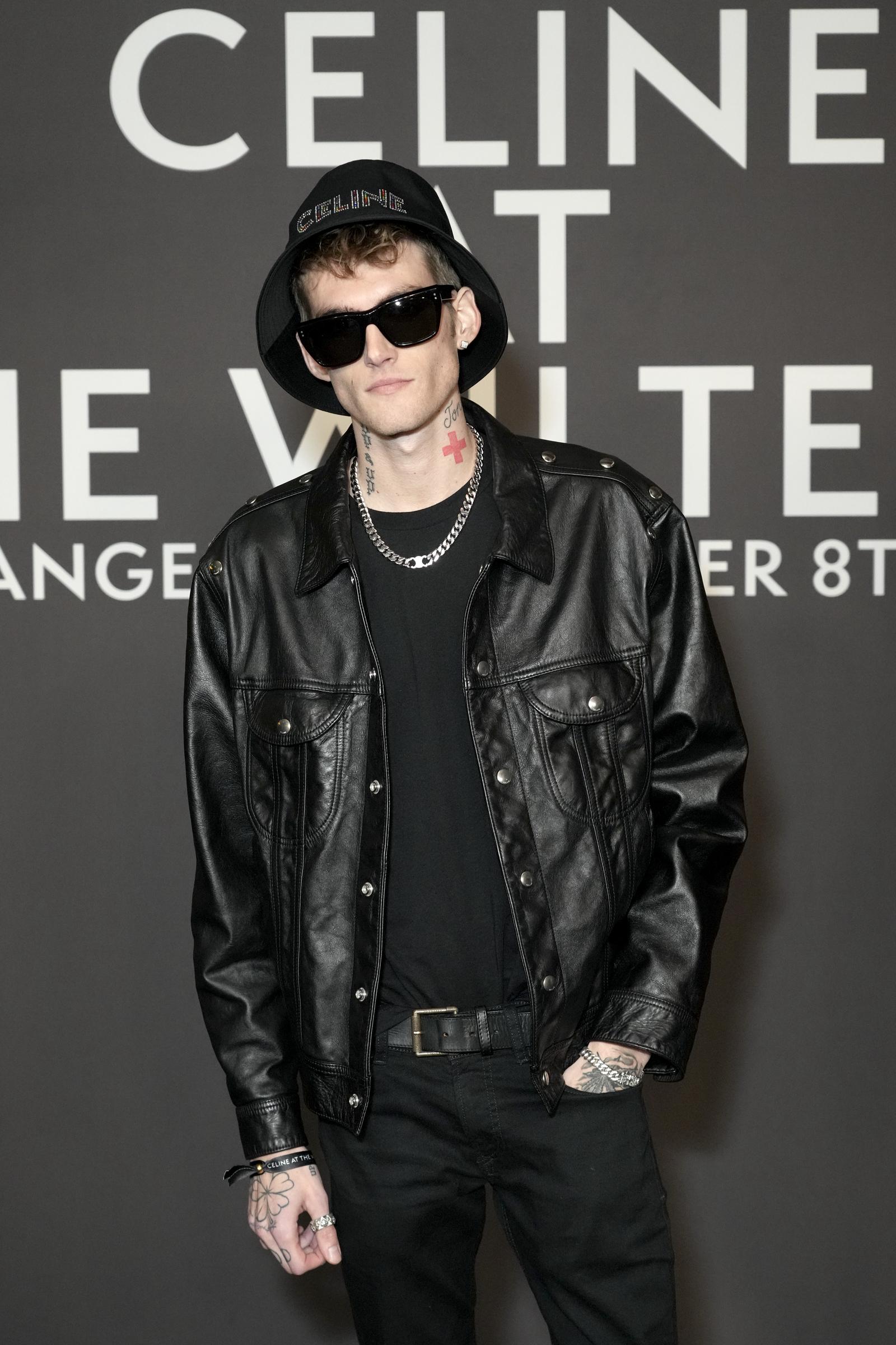 Presley Gerber leaned into an edgy street-style look featuring a black leather jacket, dark shades, a branded bucket hat, and silver chain jewelry while attending the Celine fashion show at The Wiltern on December 8, 2022, in Los Angeles, California. | Source: Getty Images