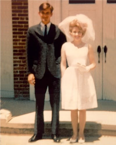 Dolly Parton and Carl Dean stood side by side on their wedding day, offering an early glimpse of the famously private relationship that would endure for nearly six decades. Parton wore a short white dress and veil, while Dean chose a dark suit for the occasion. The couple married on May 30, 1966, in Ringgold, Georgia. The throwback image was shared in a post dated March 4, 2025. | Source: Facebook/One Country