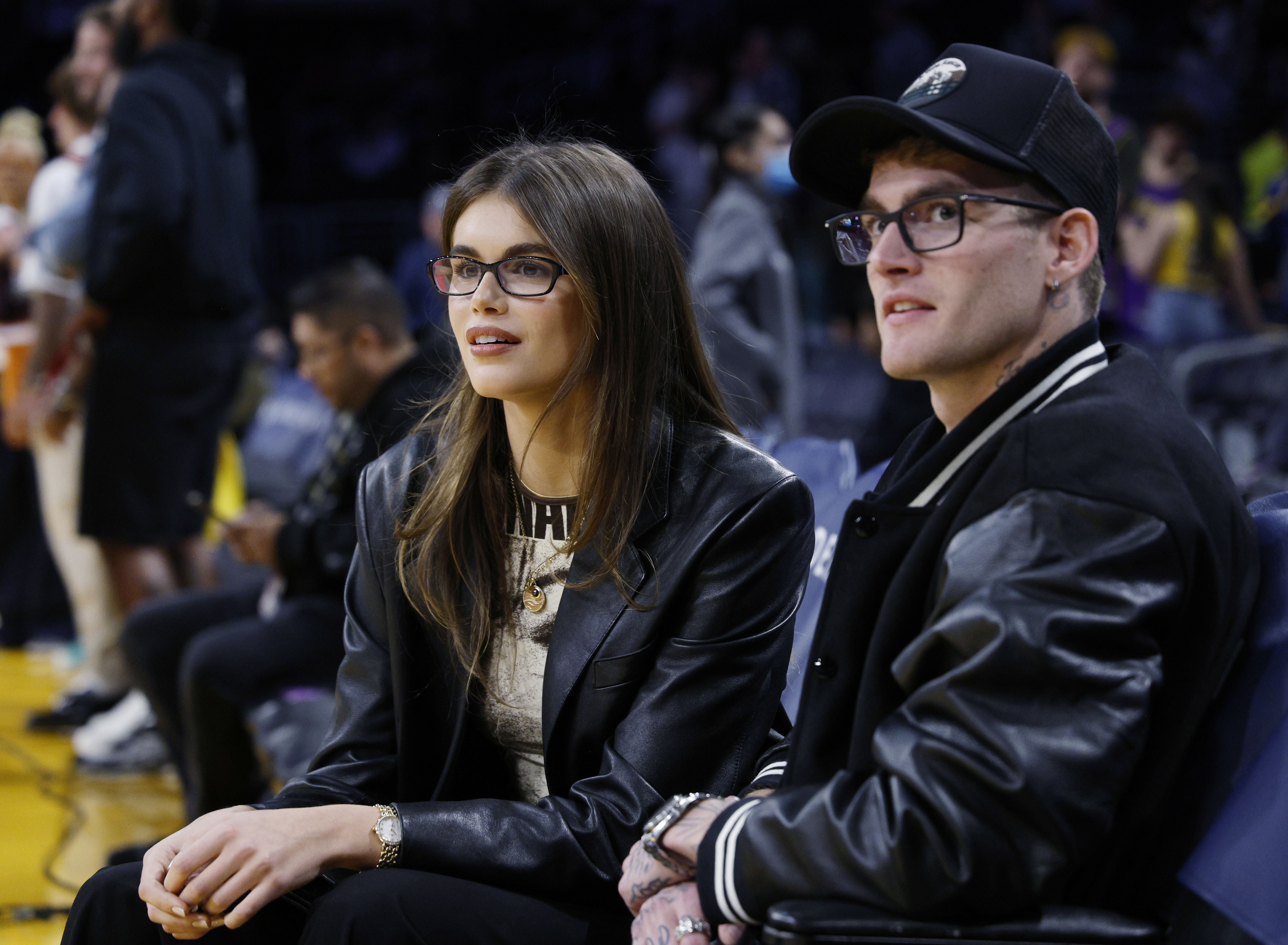 Kaia Gerber and Presley Gerber sat courtside in matching black leather looks and stylish eyeglasses during the Los Angeles Lakers and San Antonio Spurs game at Crypto.com Arena on February 23, 2024, in Los Angeles, California. The fashionable siblings showed off their close bond while taking in the action, with Kaia pairing a chic leather blazer with subtle gold jewelry and Presley sporting a two-tone varsity bomber jacket over a black baseball cap. | Source: Getty Images