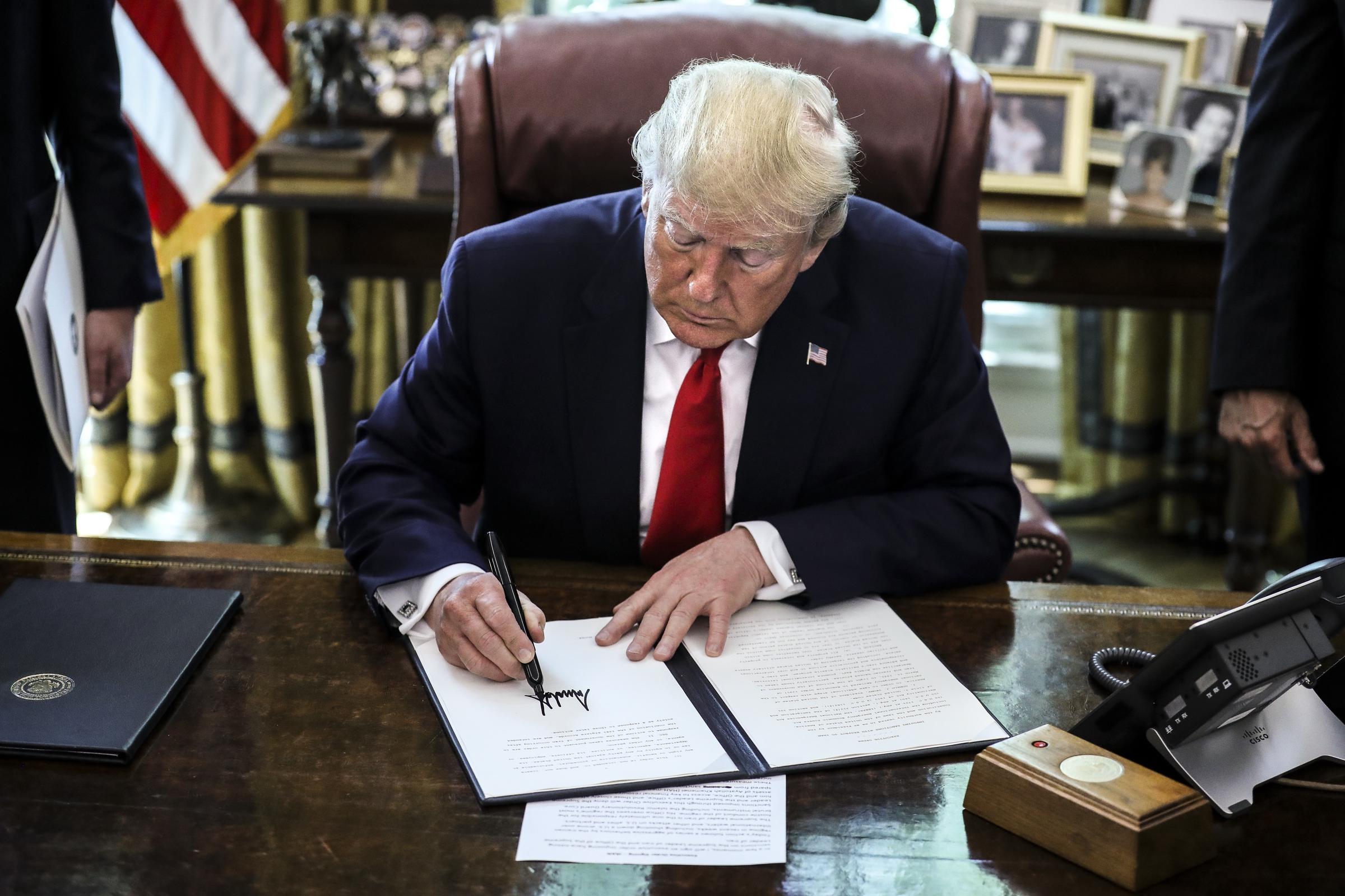 President Donald Trump signs an executive order imposing fresh sanctions on Iran in the Oval Office of the White House on June 24, 2019, in Washington, DC. | Source: Getty Images