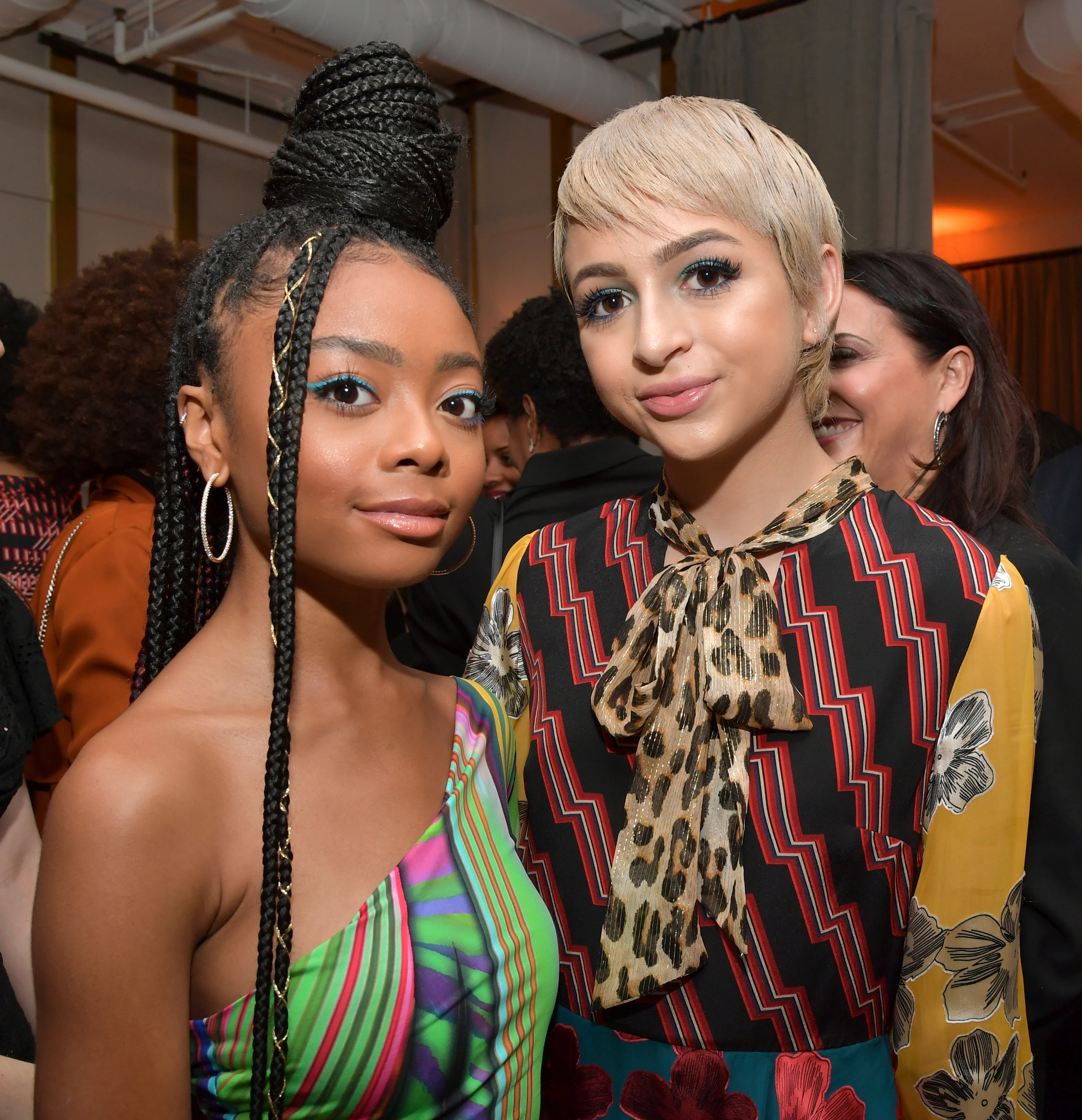 Josie Totah and Skai Jackson pose together as Marie Claire honors Hollywood's Change Makers in Los Angeles, California. Totah wears a multicolored patterned outfit with a large bow at the neckline, while Jackson sports a colorful striped dress and long braids. | Source: Getty Images