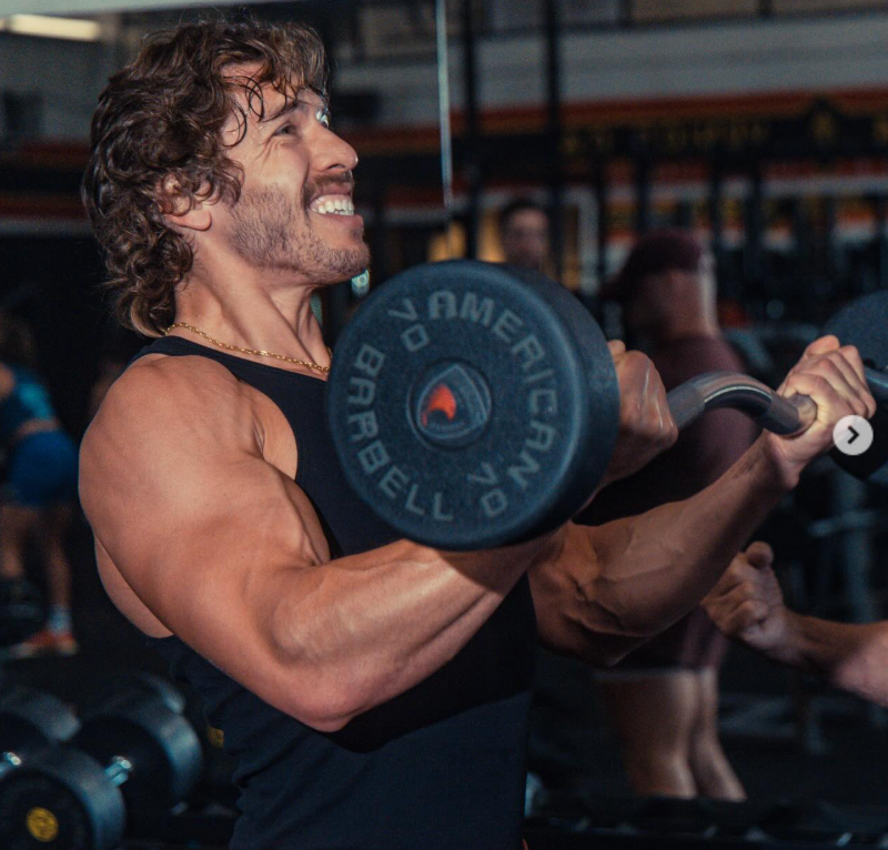 Focused and powerful, Joseph Baena drives through a bicep curl, muscles flexed and expression intense, embodying discipline and strength inside the gym. | Source: Instagram/joebaena