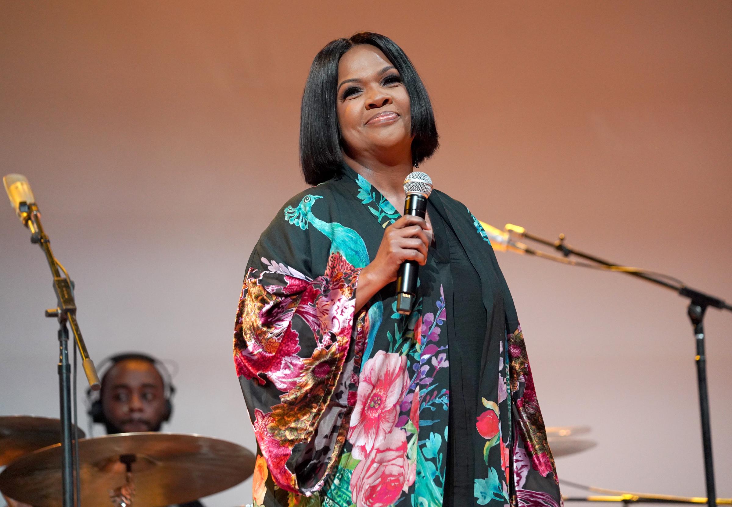 CeCe Winans smiles softly while holding a microphone onstage during BMI's Trailblazers of Gospel Music Awards in Nashville, Tennessee, on March 31, 2022.