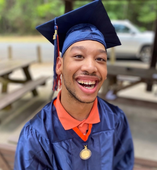 Chancellor Lee Adams beamed in a navy cap and gown as he celebrated his high school graduation in a photo shared on July 1, 2021. Wearing a medal around his neck, Cherica Adams' son marked a major milestone more than two decades after surviving the shooting that ultimately claimed his mother's life and left him with cerebral palsy and permanent brain damage. | Source: Instagram/ericaexclusive
