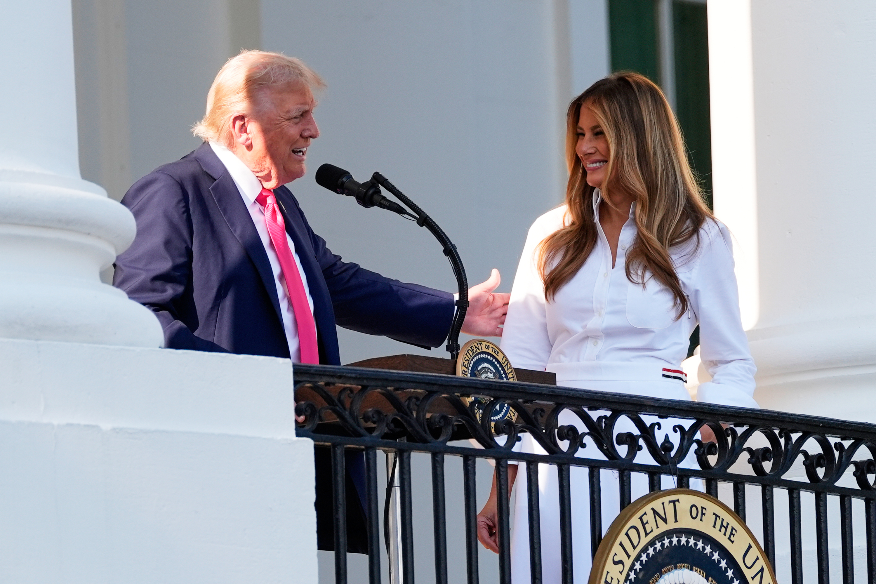 Donald Trump gesturing to Melania Trump as he speaks to a crowd during an Independence Day military family picnic in Washington, DC on July 4, 2025. | Source: Getty Images