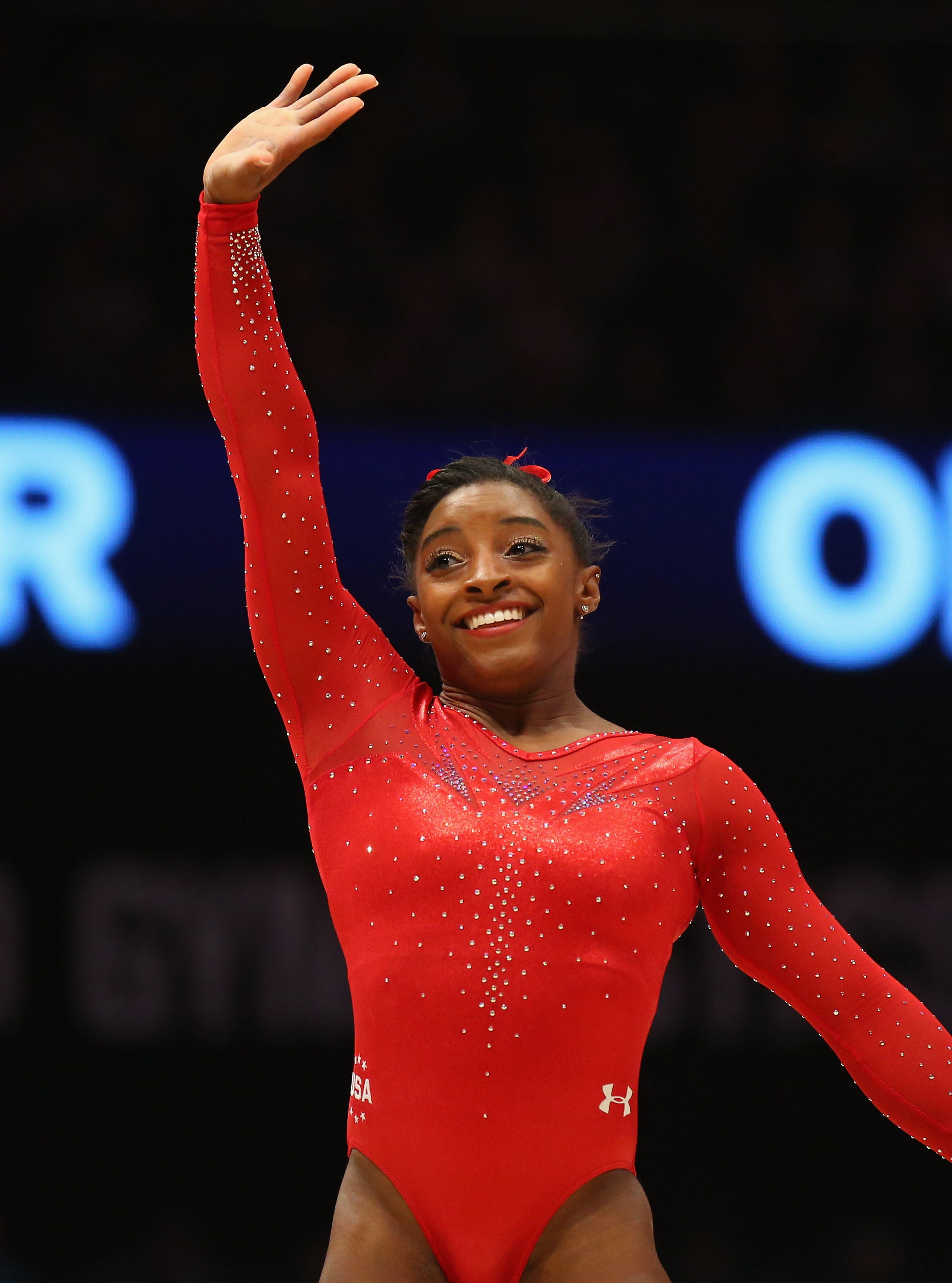 With one arm raised high and a confident smile, Simone Biles shines in a sparkling red leotard after her floor routine at the World Championships in Glasgow on October 29, 2015.