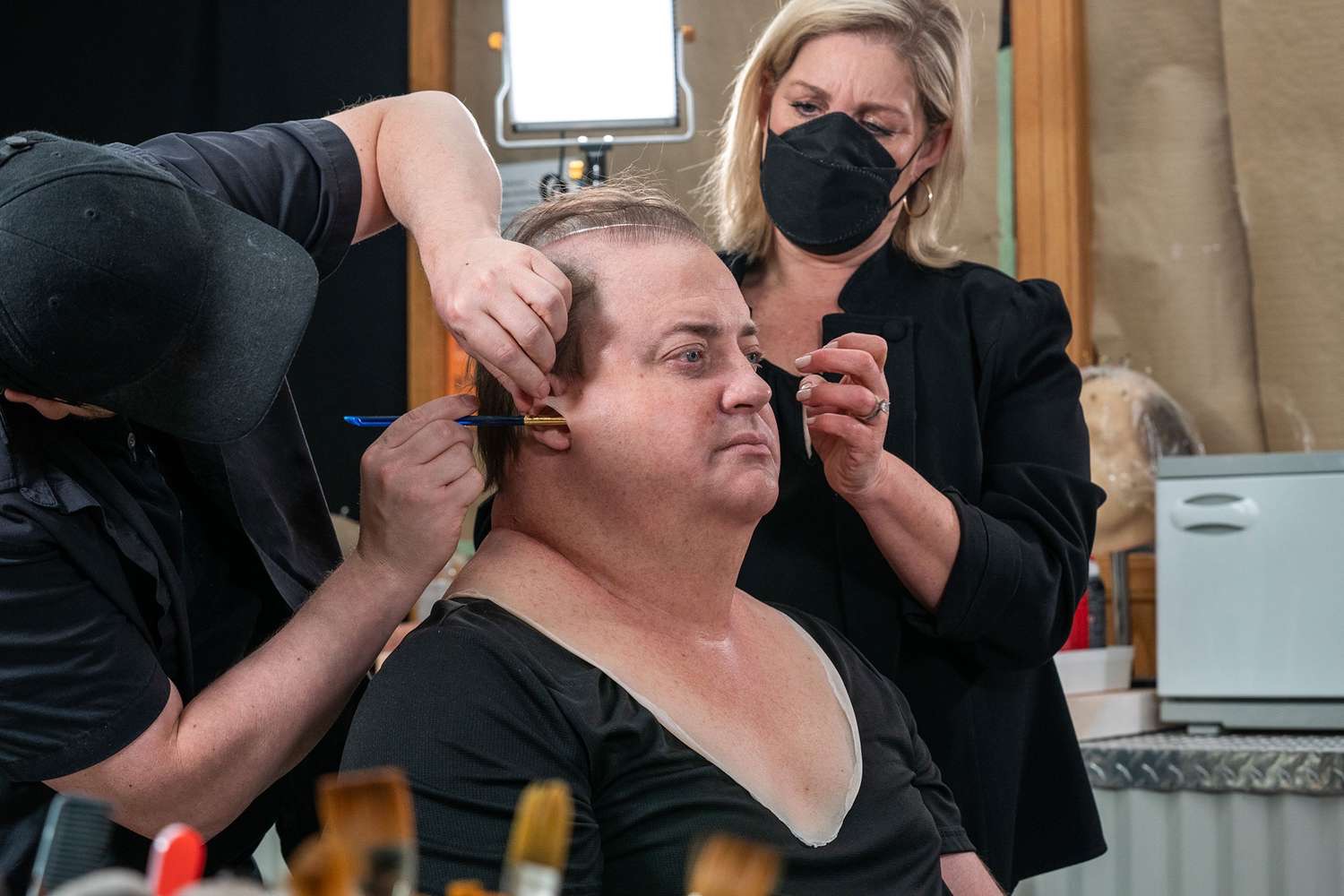 Brendan Fraser undergoing his transformation into Charlie for "The Whale," with makeup artists applying prosthetics that took several hours to complete and helped create the character's 600-pound appearance. | Source: Getty Images