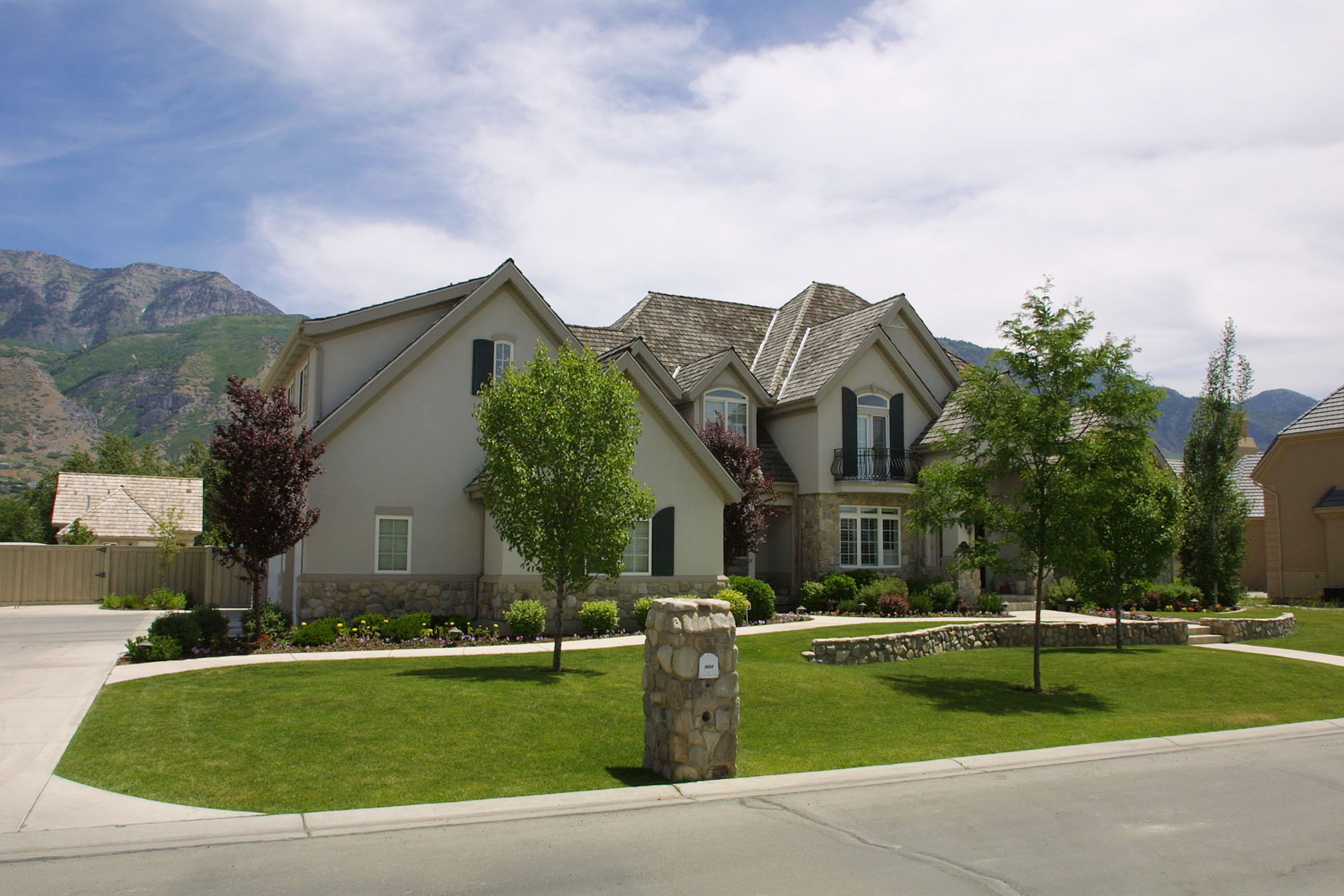 The property features a spacious lawn, mature trees, and mountain views. This side angle offers another look at Donny Osmond's home in Provo, Utah. | Source: Getty Images