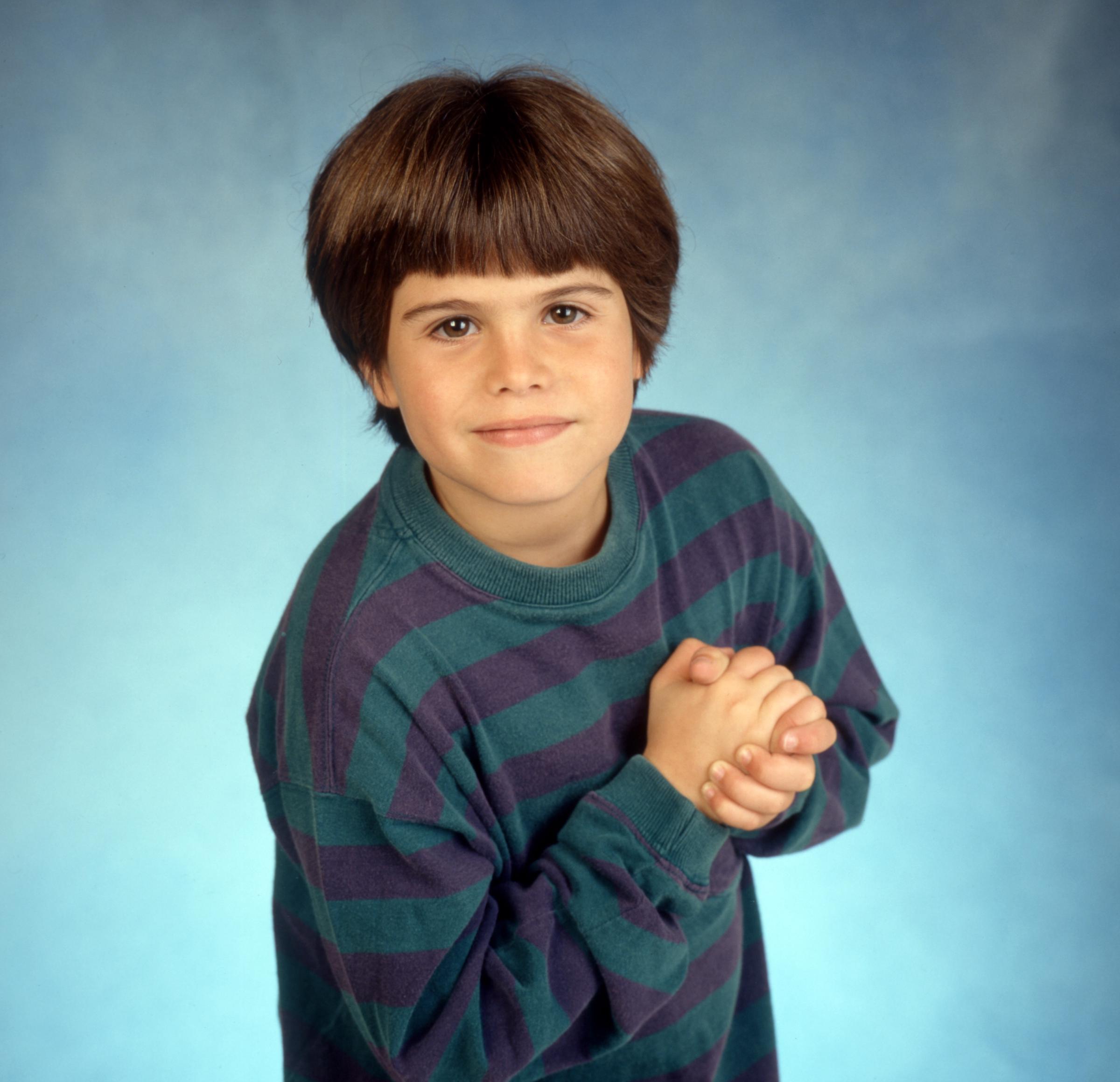 Ross Malinger poses in a striped sweater for a promotional portrait for the CBS sitcom Good Advice, which premiered in April 1993, shortly before his breakthrough in Sleepless in Seattle. | Source: Getty Images.