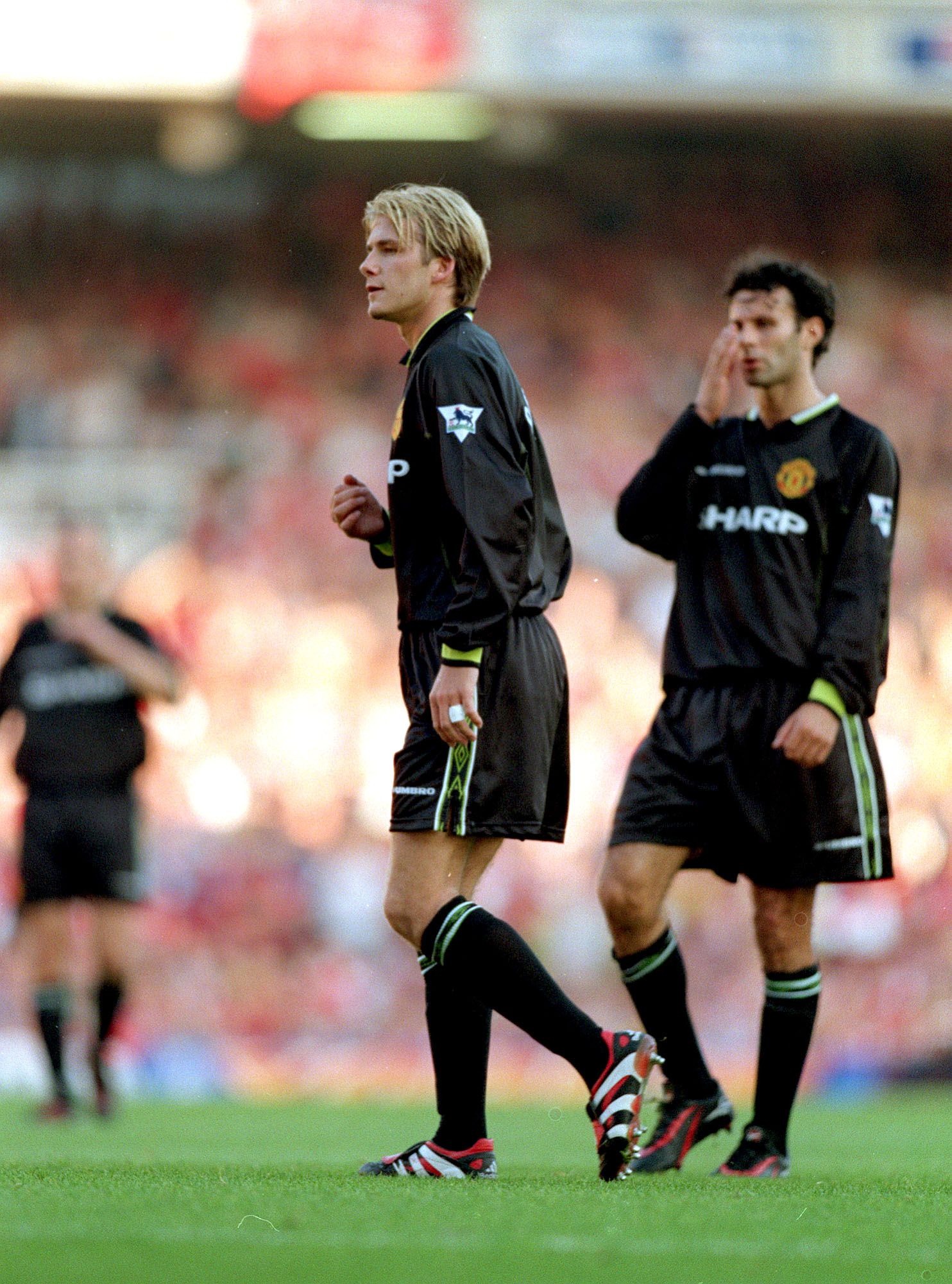 David Beckham walking on a field during a soccer game against Arsenal in 1998. | Source: Getty Images