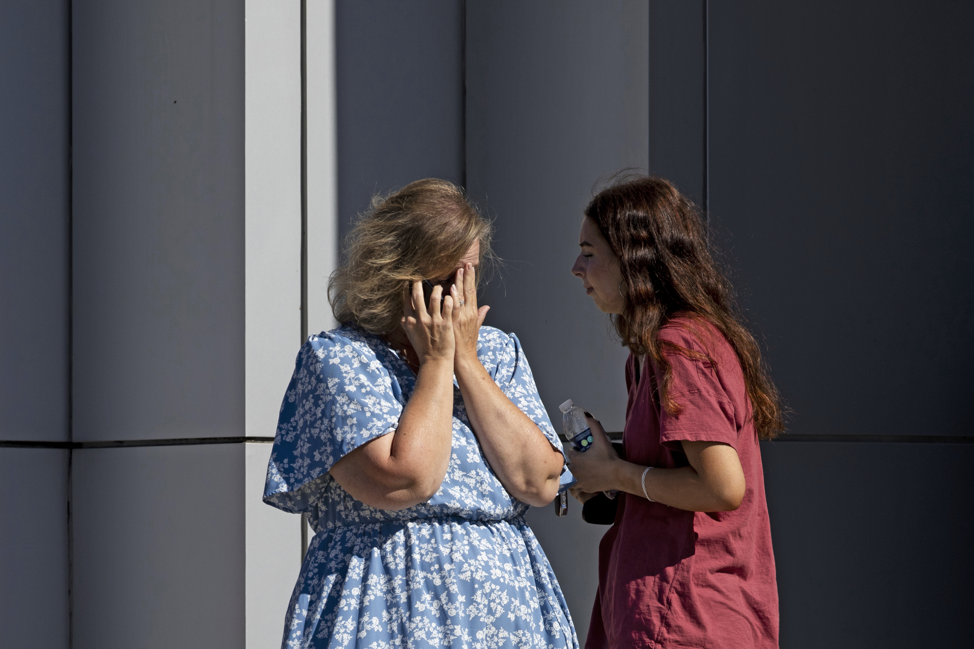 A woman is overcome with emotion on the phone as church members and residents reunite at Trillium Theater located across the street from the site of a shooting and fire at the Church of Jesus Christ of Latter-day Saints on September 28, 2025, in Grand Blanc, Michigan. | Source: Getty Images