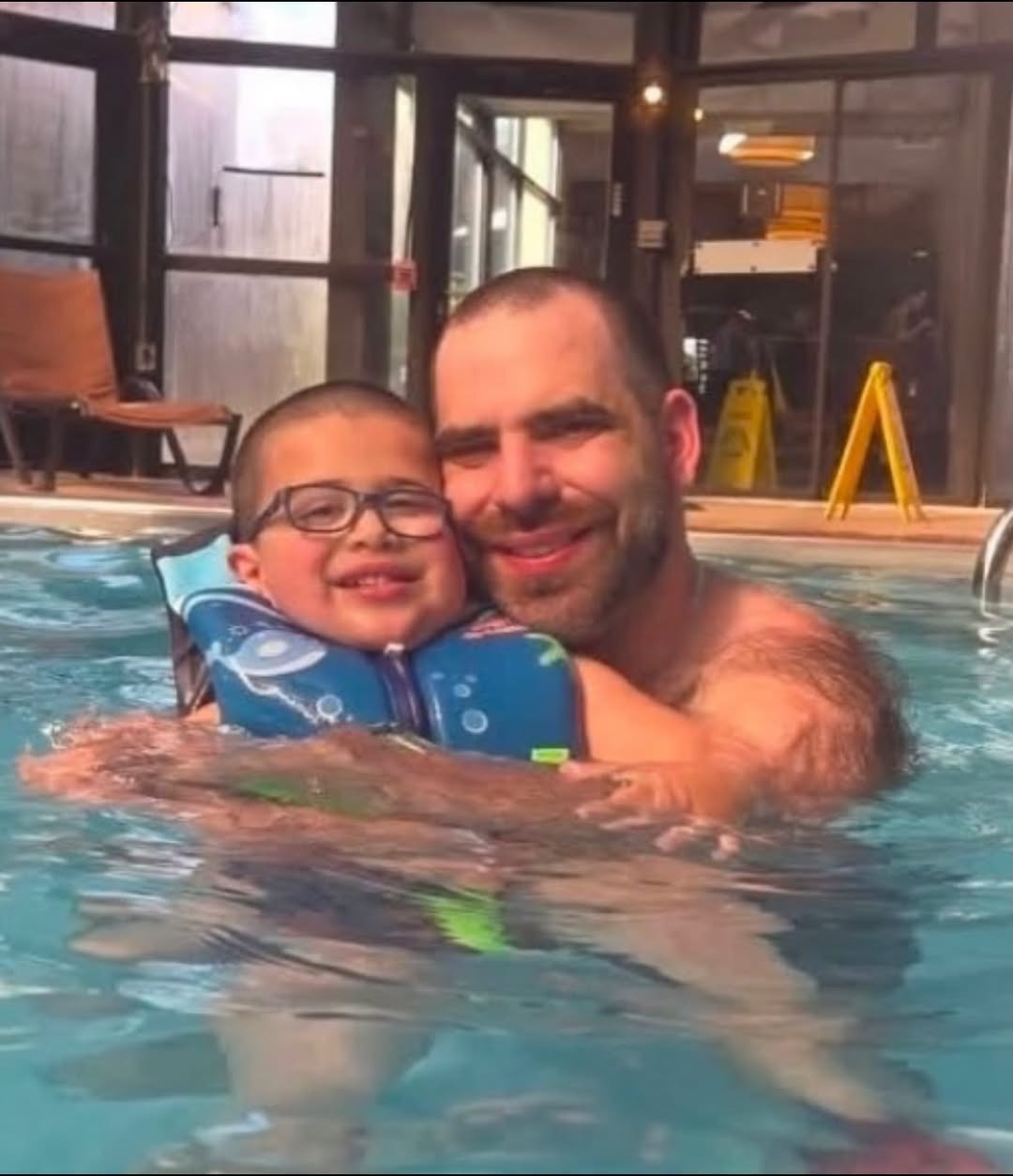 Charles “Chaz” Harrison holds his young son, Tristan, close as they share a happy moment together in a swimming pool. | Source: Facebook/Bradford County YMCA
