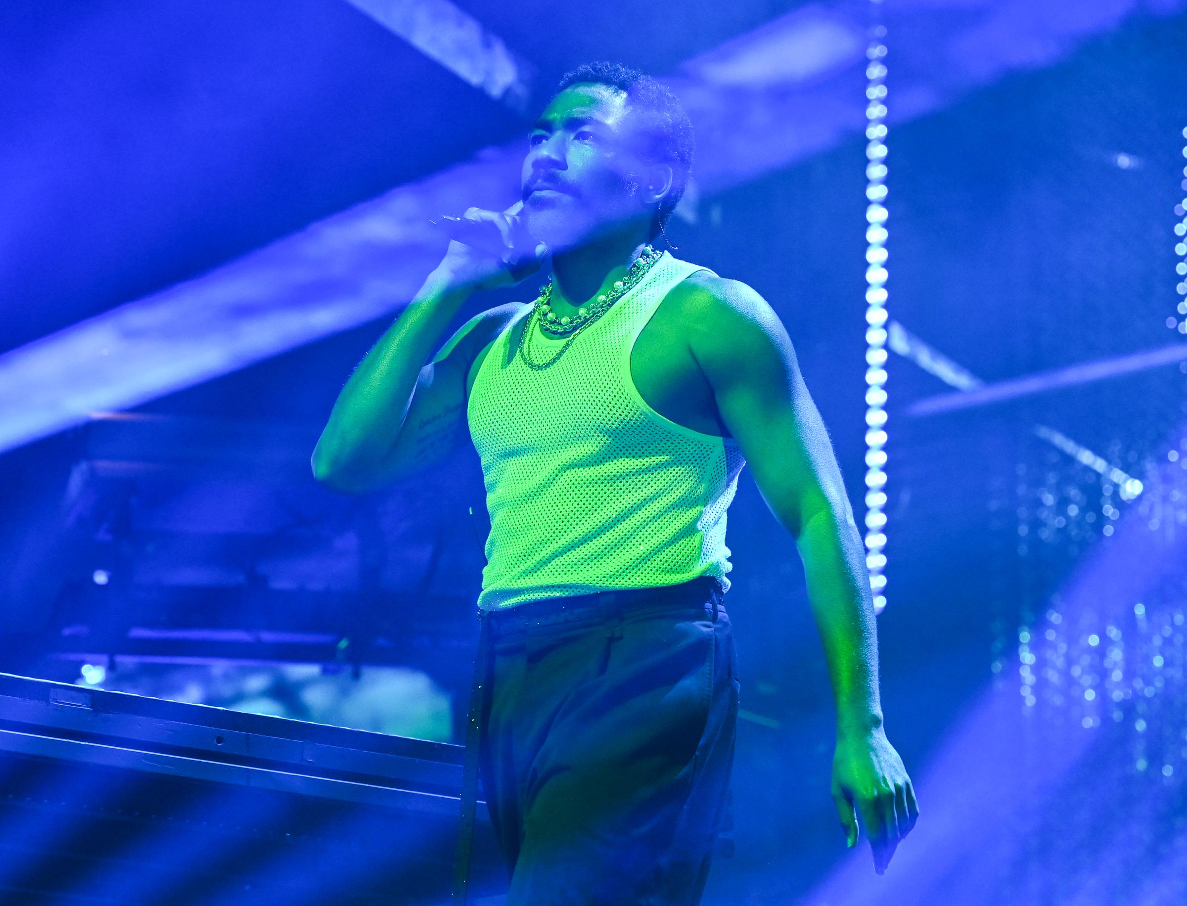 Dressed in a mesh tank top, Donald Glover takes the stage at Camp Flog Gnaw Carnival 2025, delivering a high-energy set at Dodger Stadium | Source: Getty Images