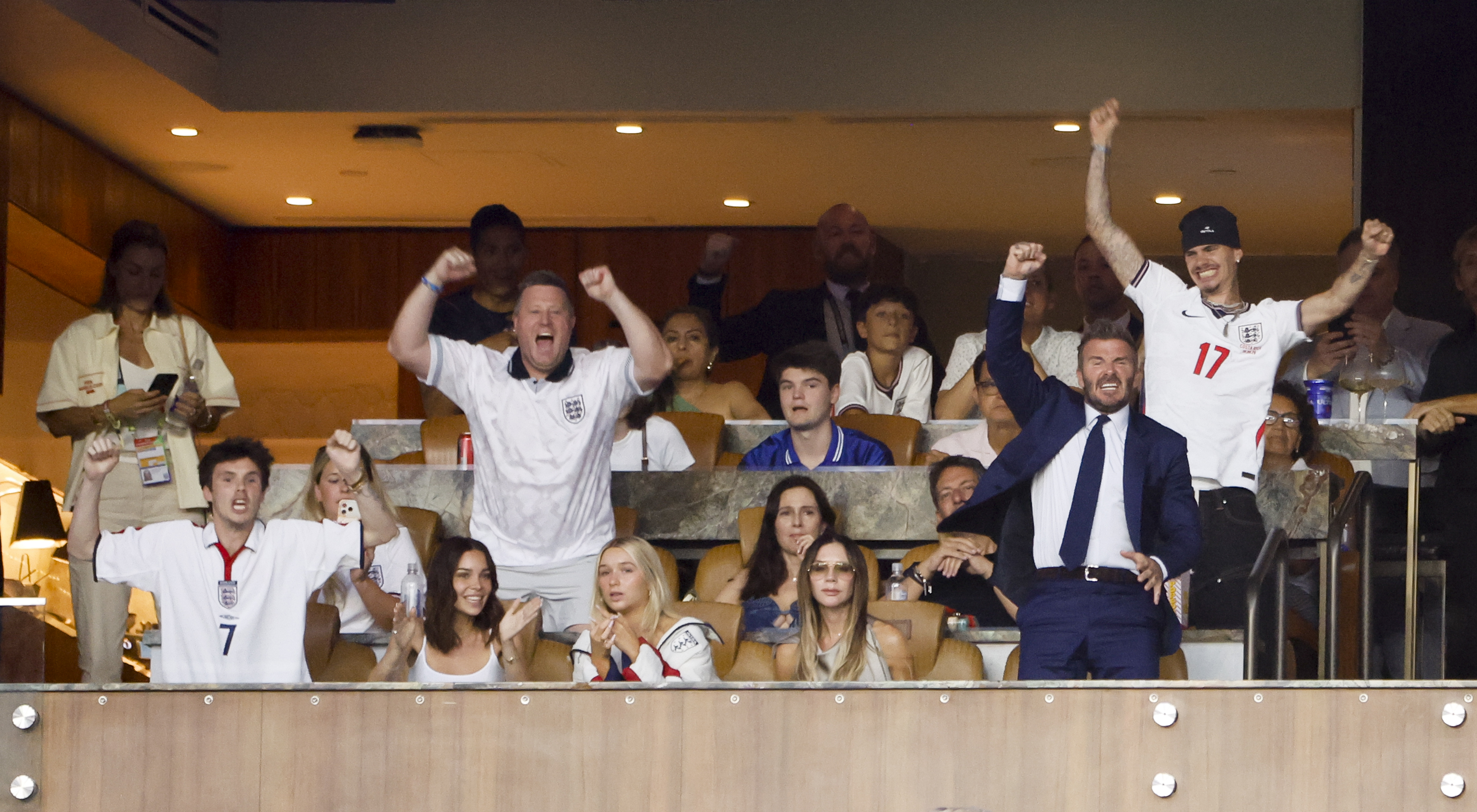 David, Victoria, Cruz, and Romeo Beckham cheer energetically during a high-stakes moment of the soccer tournament, fully immersed in the action of football's biggest night in a luxury stadium suite. | Source: Getty Images