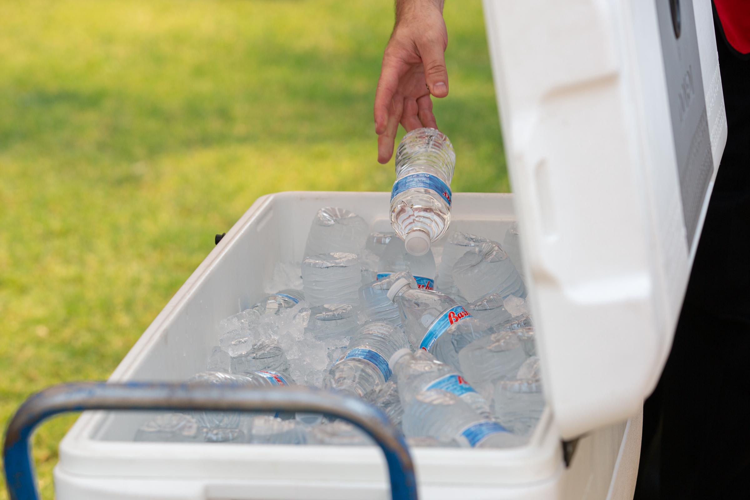 A person picks up a bottle of water from a cooler at a heat relief station in Phoenix, Arizona, on June 15, 2021 | Source: Getty Images