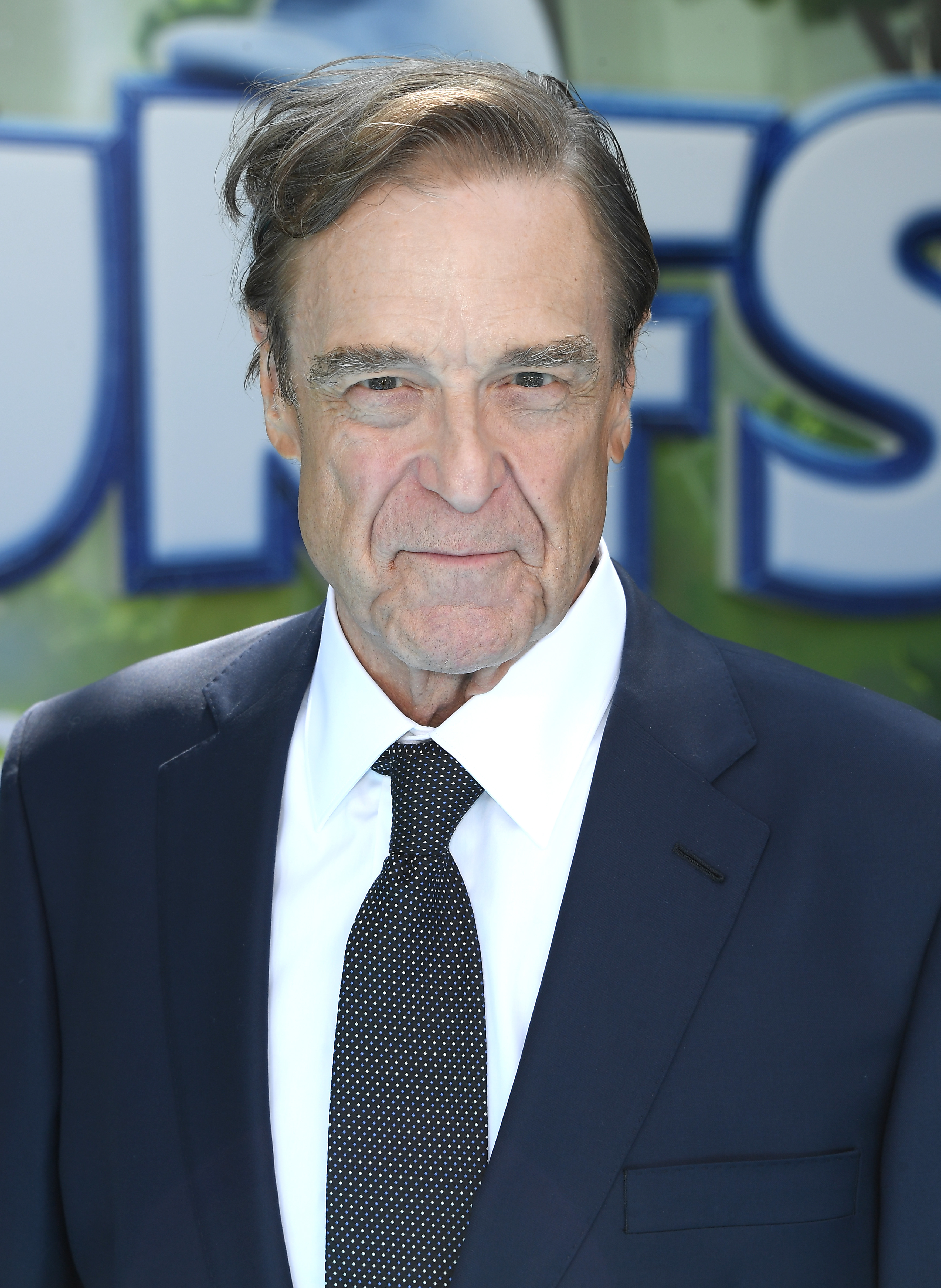 In 2025, Goodman appeared notably slimmer and confident in a navy suit paired with a crisp white shirt and a dotted black tie, highlighting his impressive weight loss. His composed expression and neatly styled hair reflect a poised and confident presence on the "The Smurfs Movie" premiere red carpet.