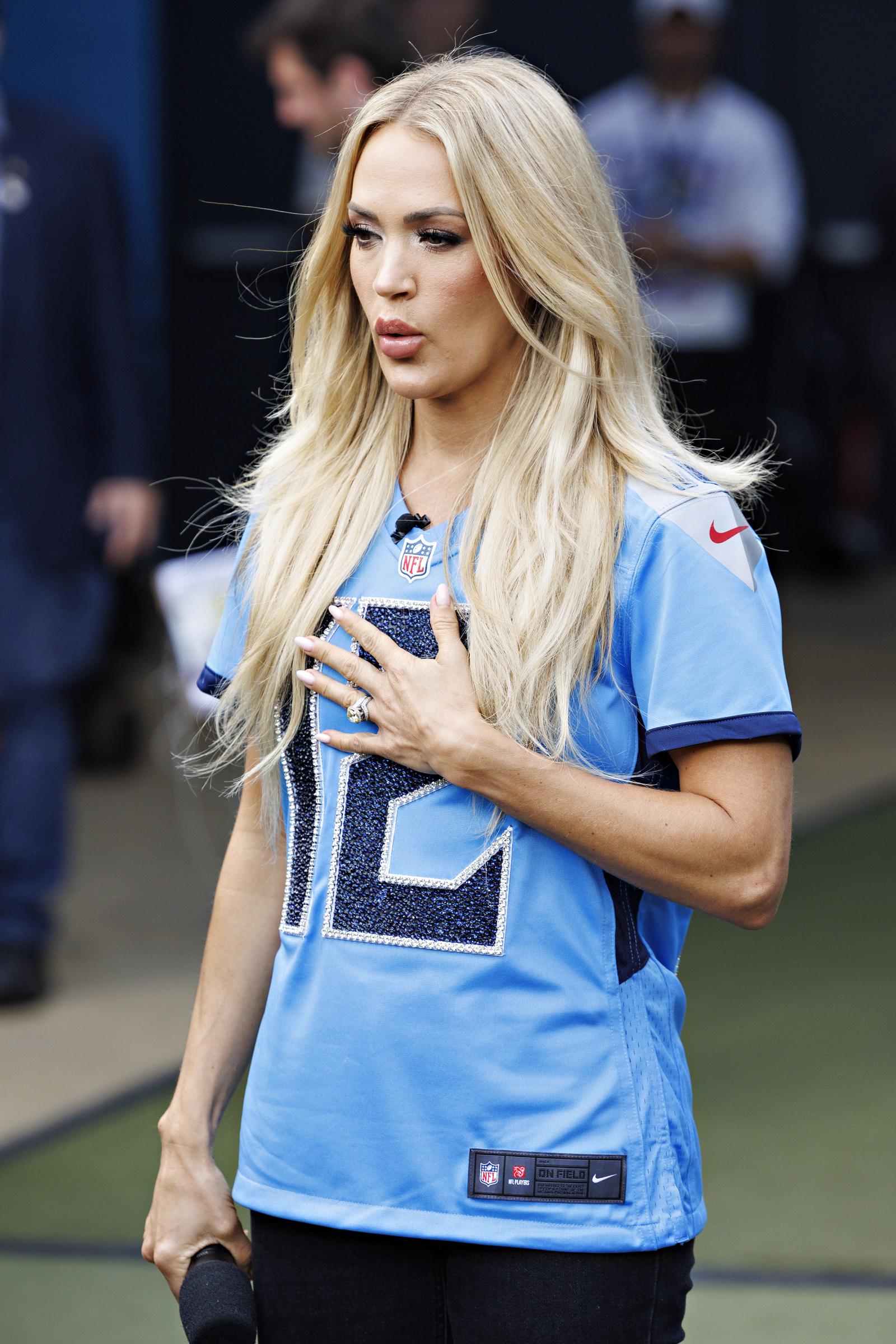 Carrie Underwood placed her hand over her heart before the Tennessee Titans' game against the New England Patriots in Nashville in November 2024. The appearance came during a year when public interest in her changing look remained high. | Source: Getty Images