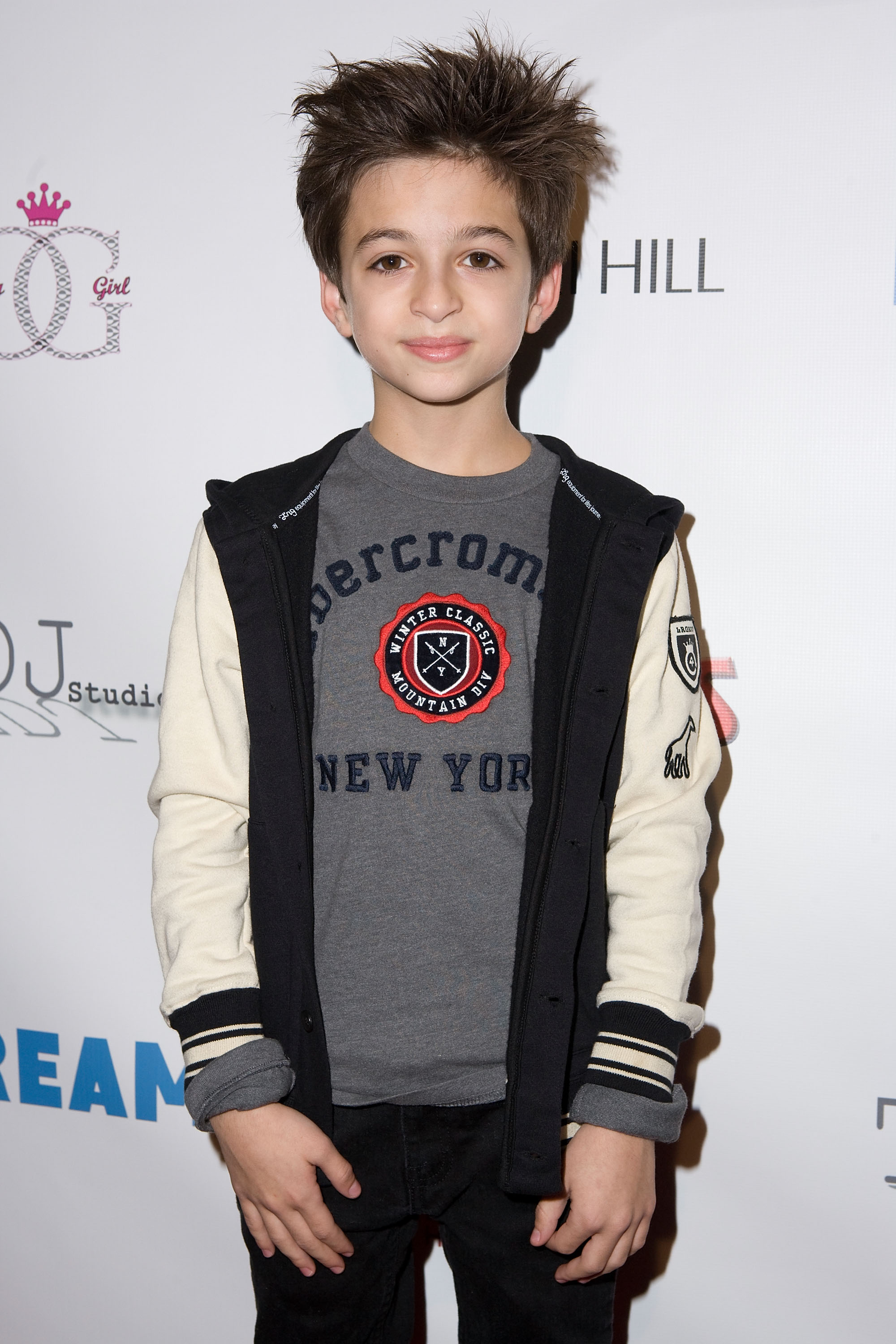The young performer attends the 2nd Annual Dream Magazine Winter Wonderland Party in Los Angeles, California, wearing a gray graphic T-shirt, a black-and-cream jacket, and black pants. | Source: Getty Images