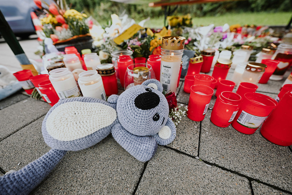 Mourners in the community leave candles and stuffed animals | Source: Getty Images