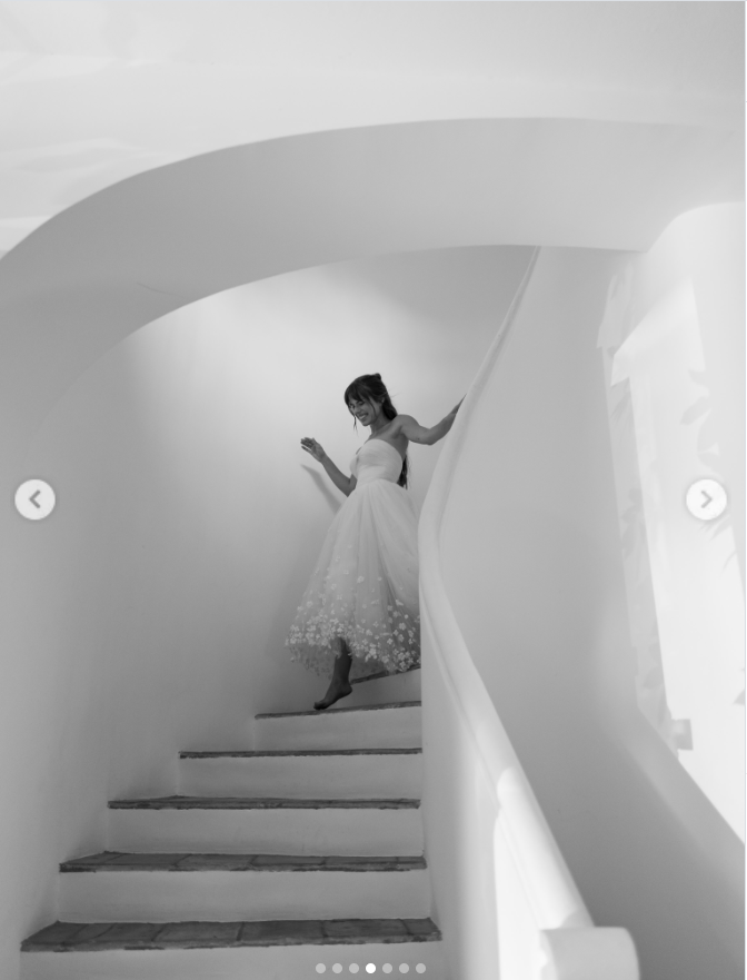 Paula carefully descended a sweeping curved staircase in a striking black-and-white frame, her strapless gown and flower-detailed skirt standing out against the sculptural white setting. | Source: Instagram/dylanjaggerlee
