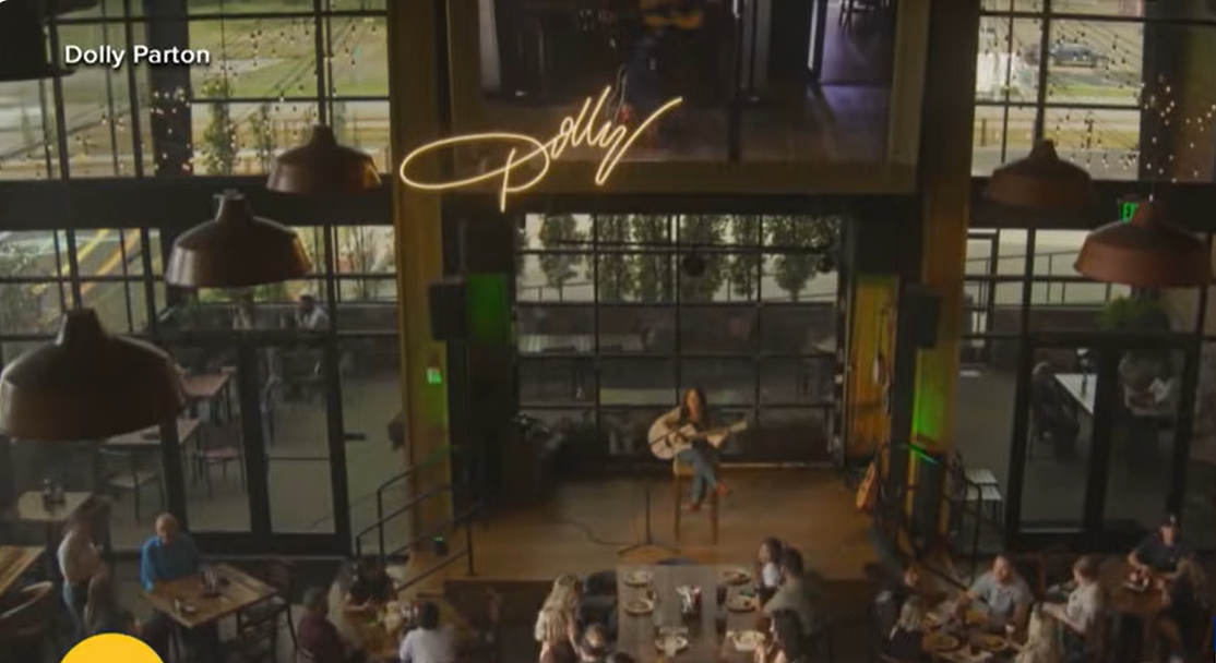 Guests gather inside Dolly's Tennessean Travel Stop as a musician performs on the venue's stage, reflecting the travel destination's blend of dining, entertainment, and Southern hospitality. | Source: YouTube/Good Morning America