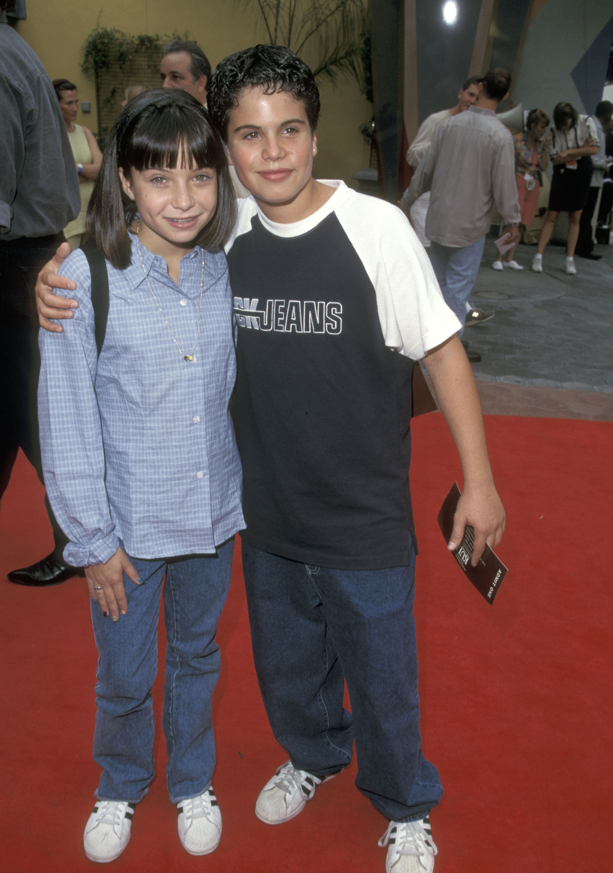 The young actor poses with a girl on the red carpet, wearing a casual CK Jeans shirt and jeans — another glimpse of his changing appearance as he grew up in Hollywood. | Source: Getty Images.