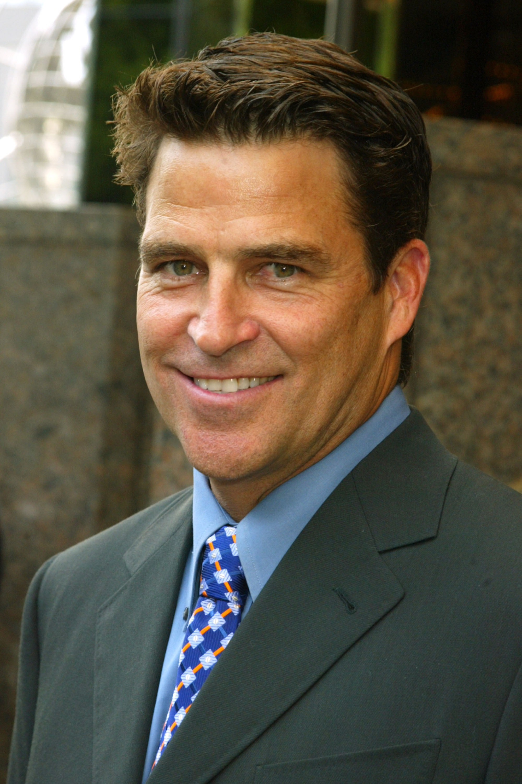 Ted McGinley smiled for the cameras during the ABC 2004–2005 Upfront arrivals at Cipriani 42nd Street on May 18, 2004, in New York City. The actor looked sharp in a dark charcoal suit jacket paired with a light blue dress shirt and a vibrant royal blue tie featuring an orange and white geometric diamond pattern. | Source: Getty Images