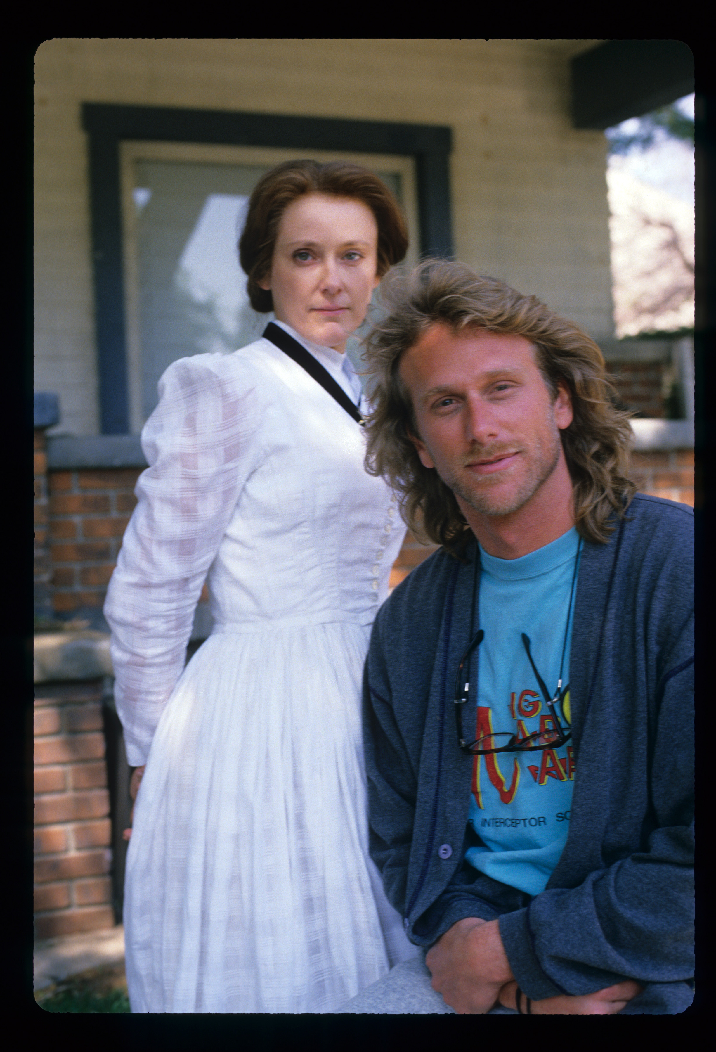 Mary Beth Hurt stands beside Peter Horton in a still from "Thirtysomething" in 1990, wearing a high-necked white dress. Her stern expression suits the dramatic tone of the episode "I'm Nobody, Who Are You."