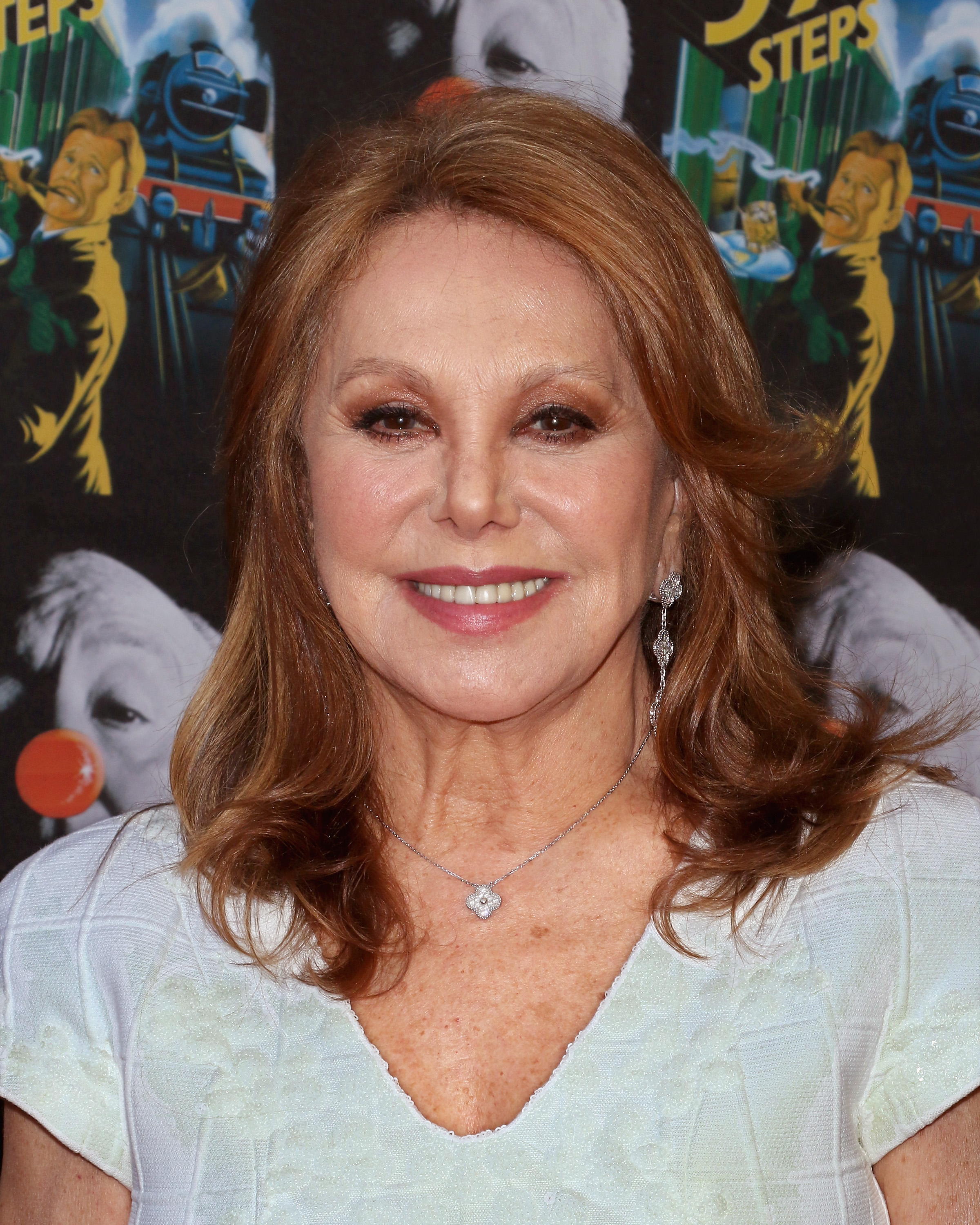 Marlo Thomas smiles on the red carpet at the opening night of "The 39 Steps," pairing a white ruffled top with sparkling jewelry and softly styled hair. | Source: Getty Images
